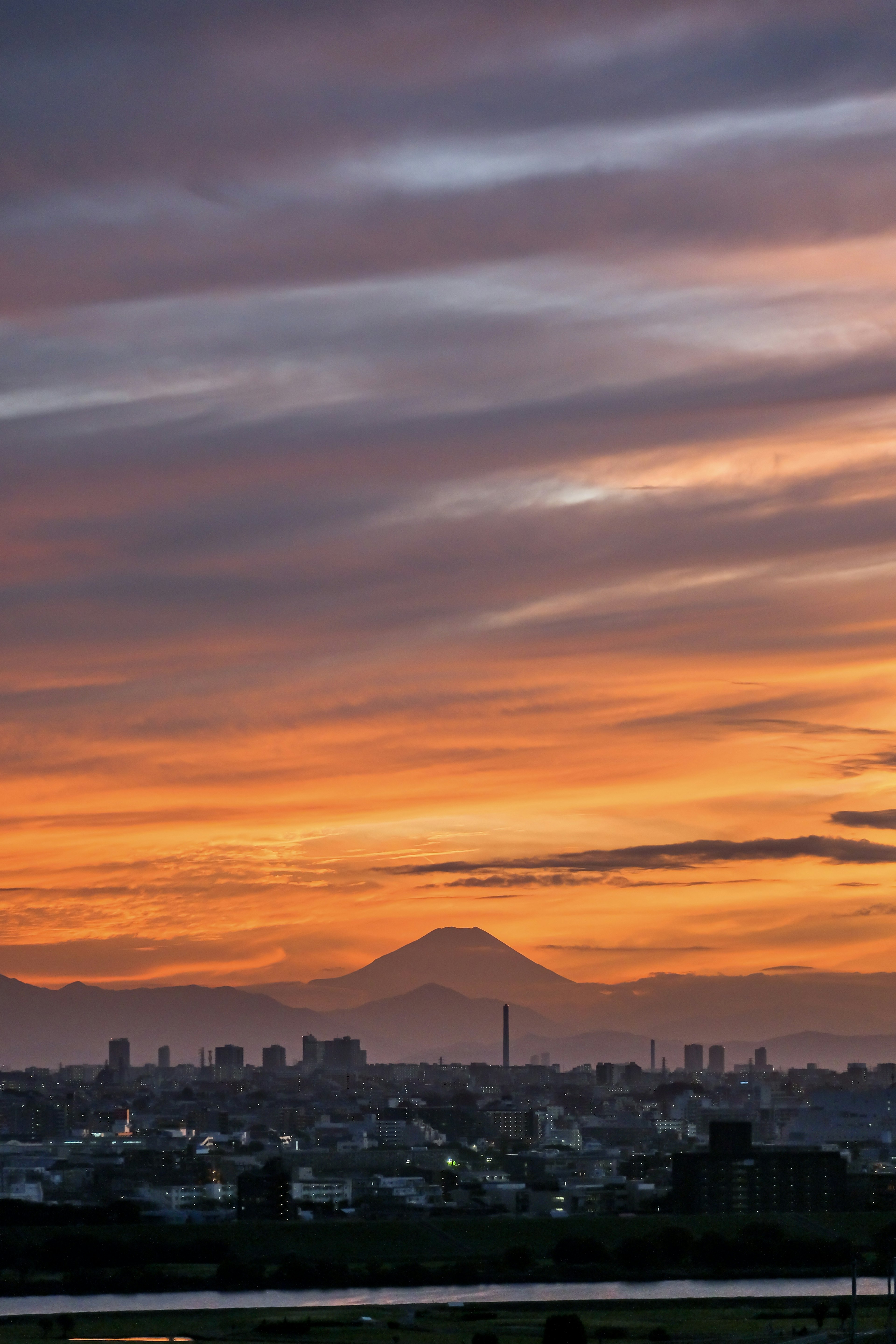 Stadtlandschaft mit Sonnenuntergang und Bergsilhouette