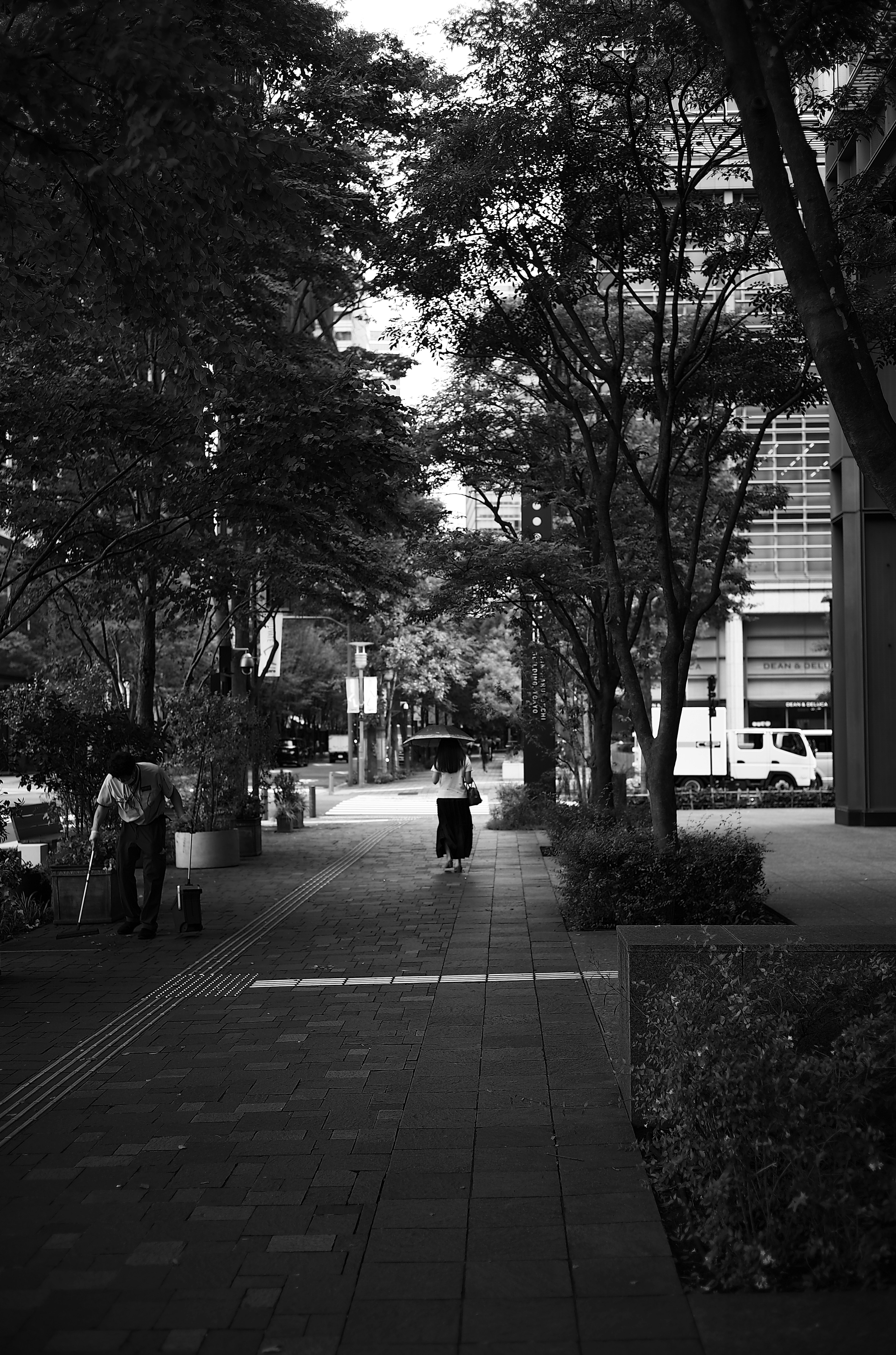 Black and white city scene featuring a person standing in the middle of the street