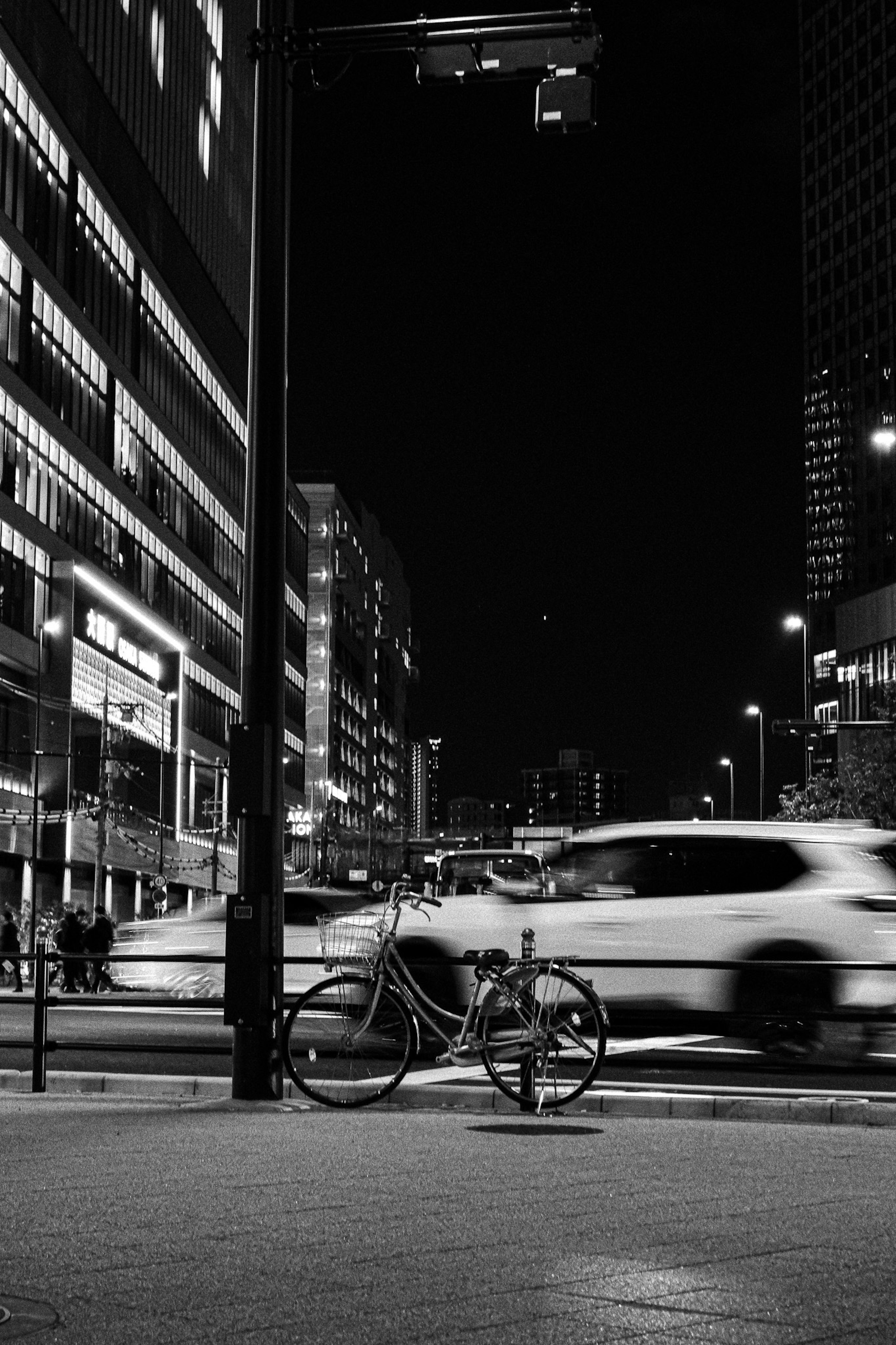 Paysage urbain nocturne avec un vélo et des voitures floues