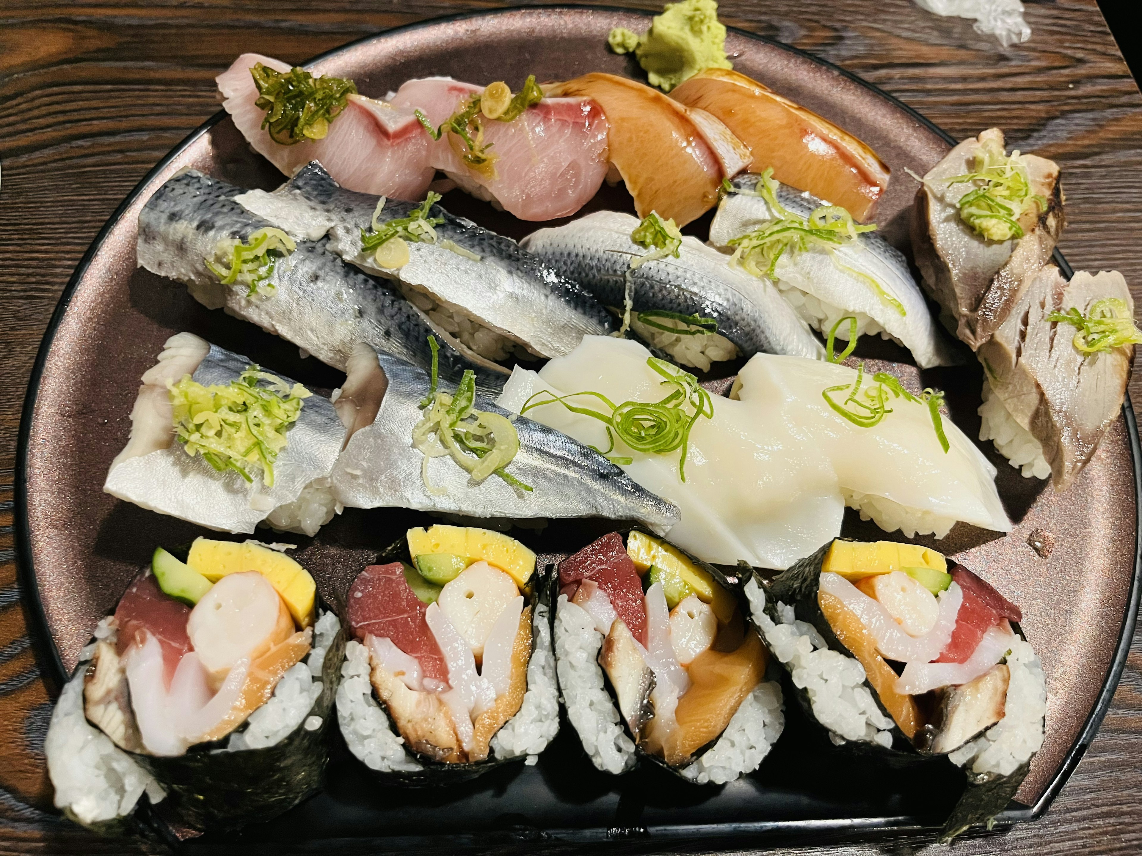 Un plato de sushi fresco que incluye varios tipos de pescado y mariscos