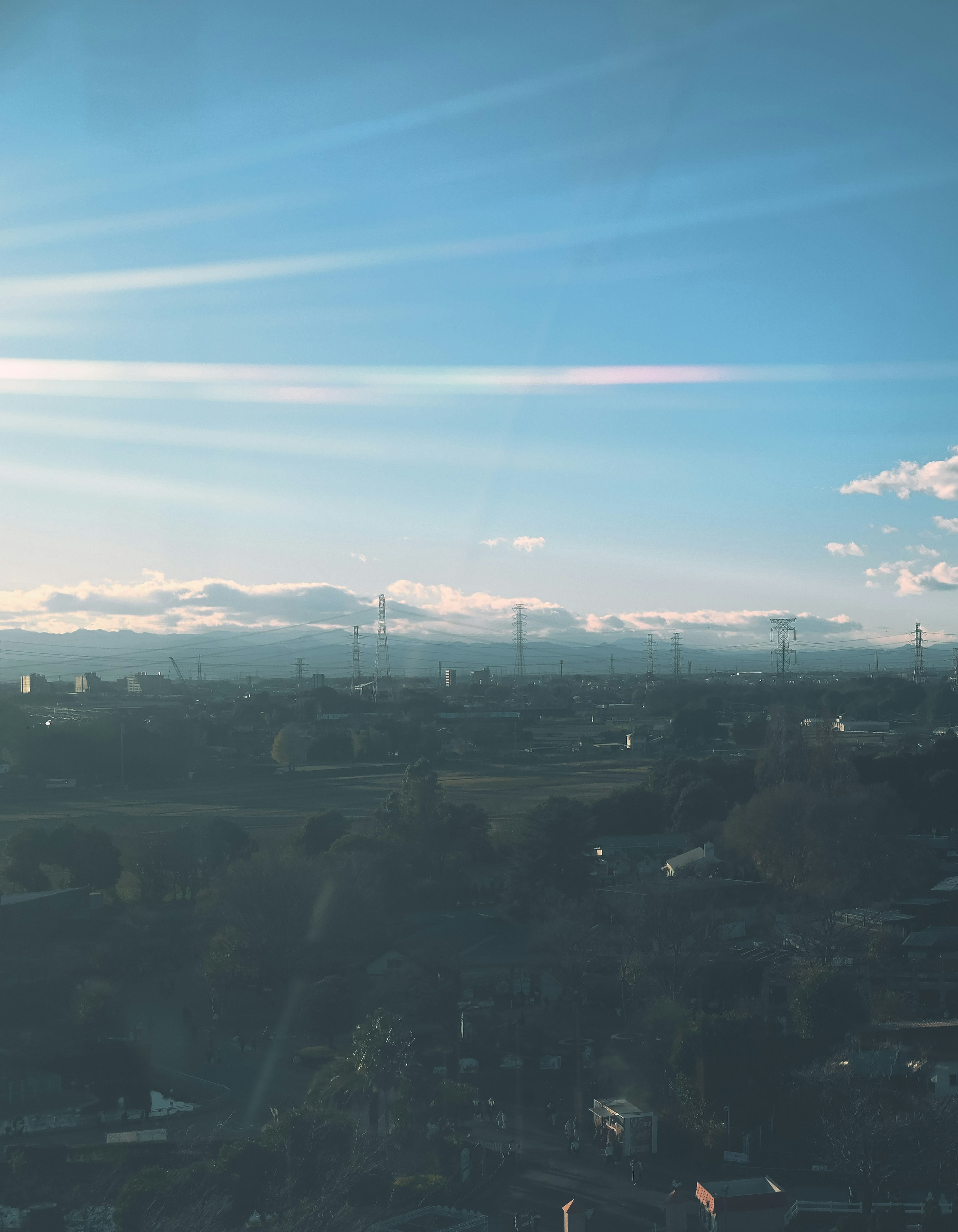 Vista escénica del cielo azul con nubes montañas y edificios distantes