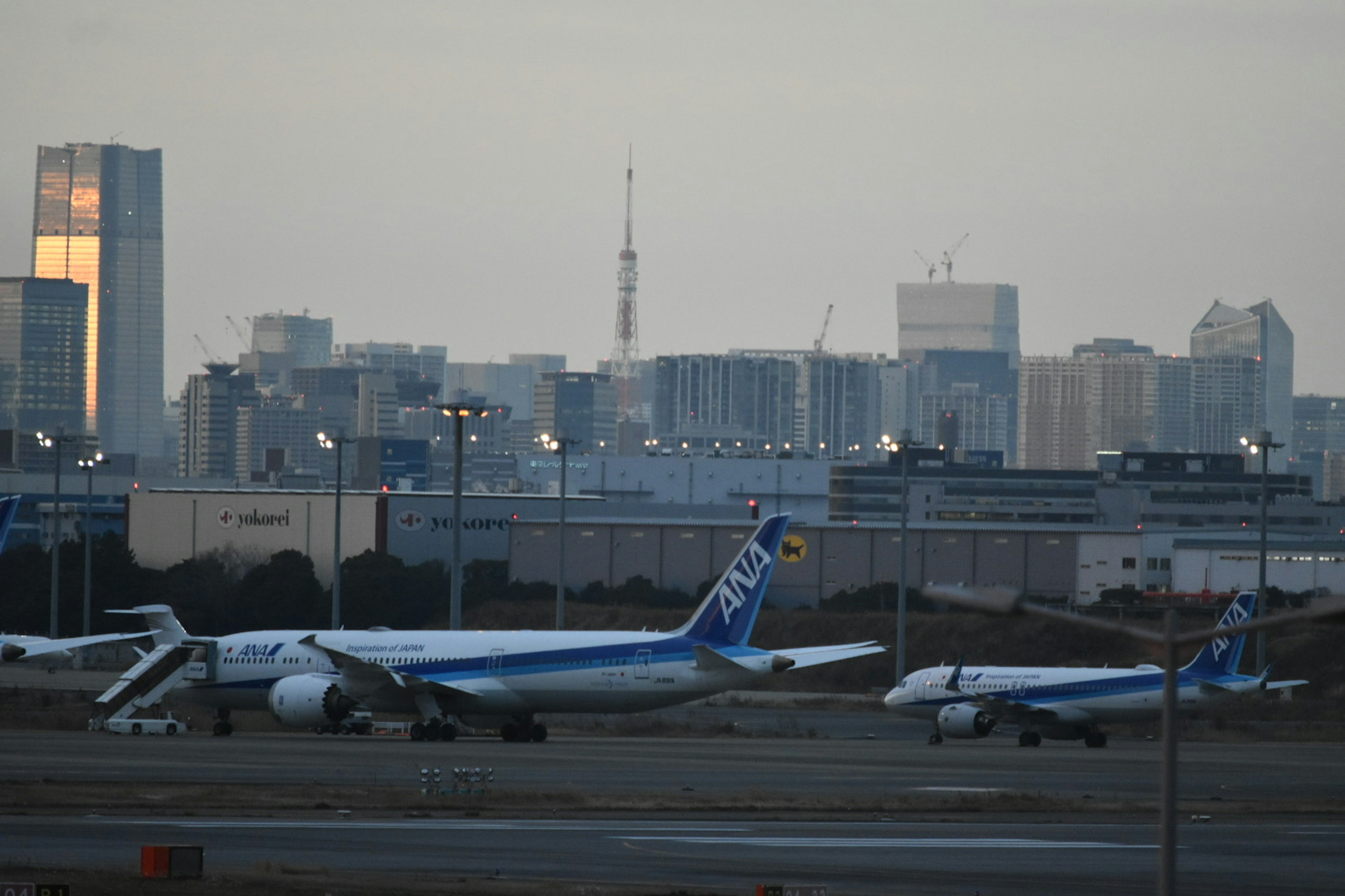 空港の滑走路に駐機している飛行機と都市の背景