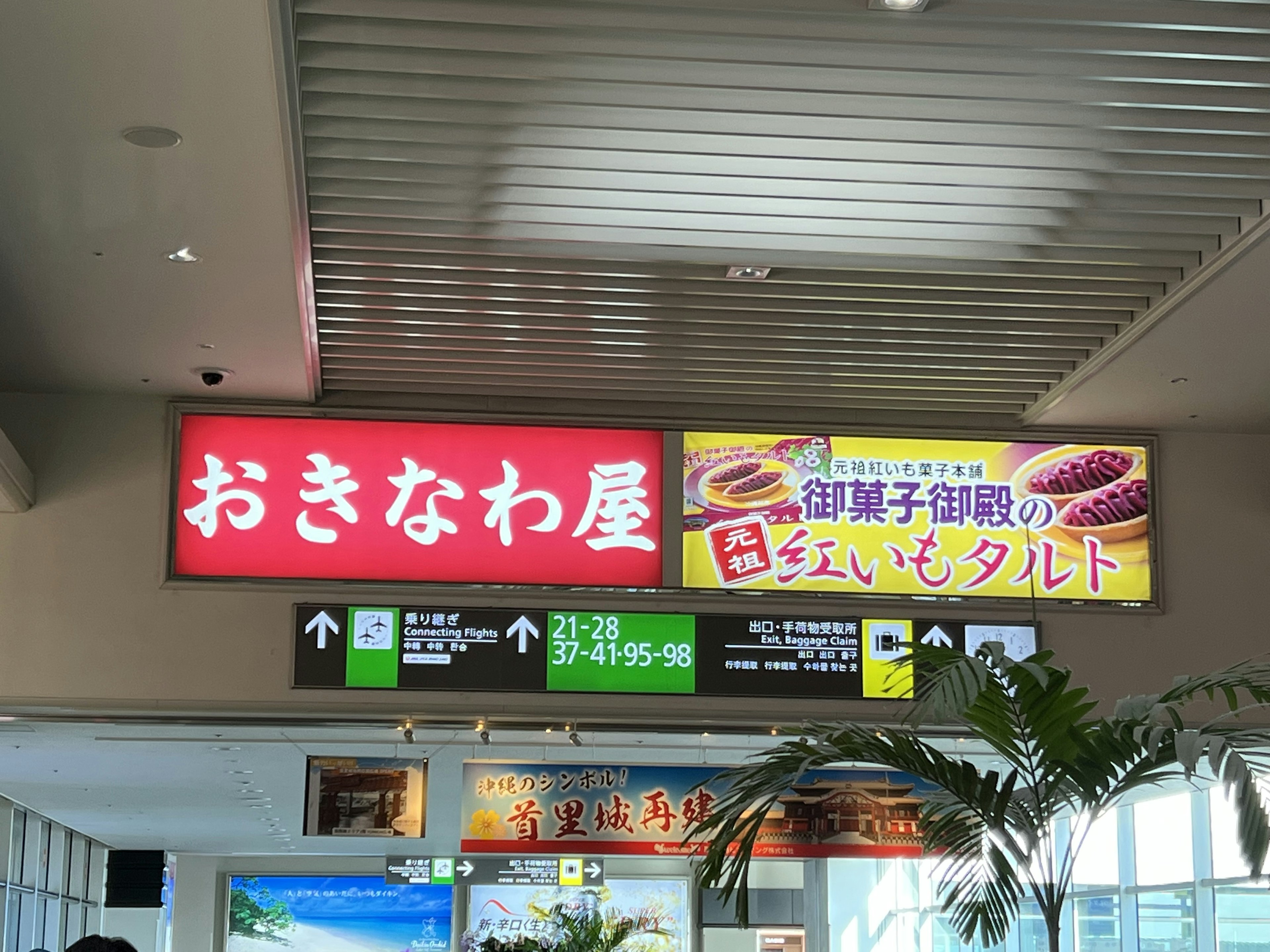 Cartel del restaurante Okinawa y anuncio de postre en un aeropuerto