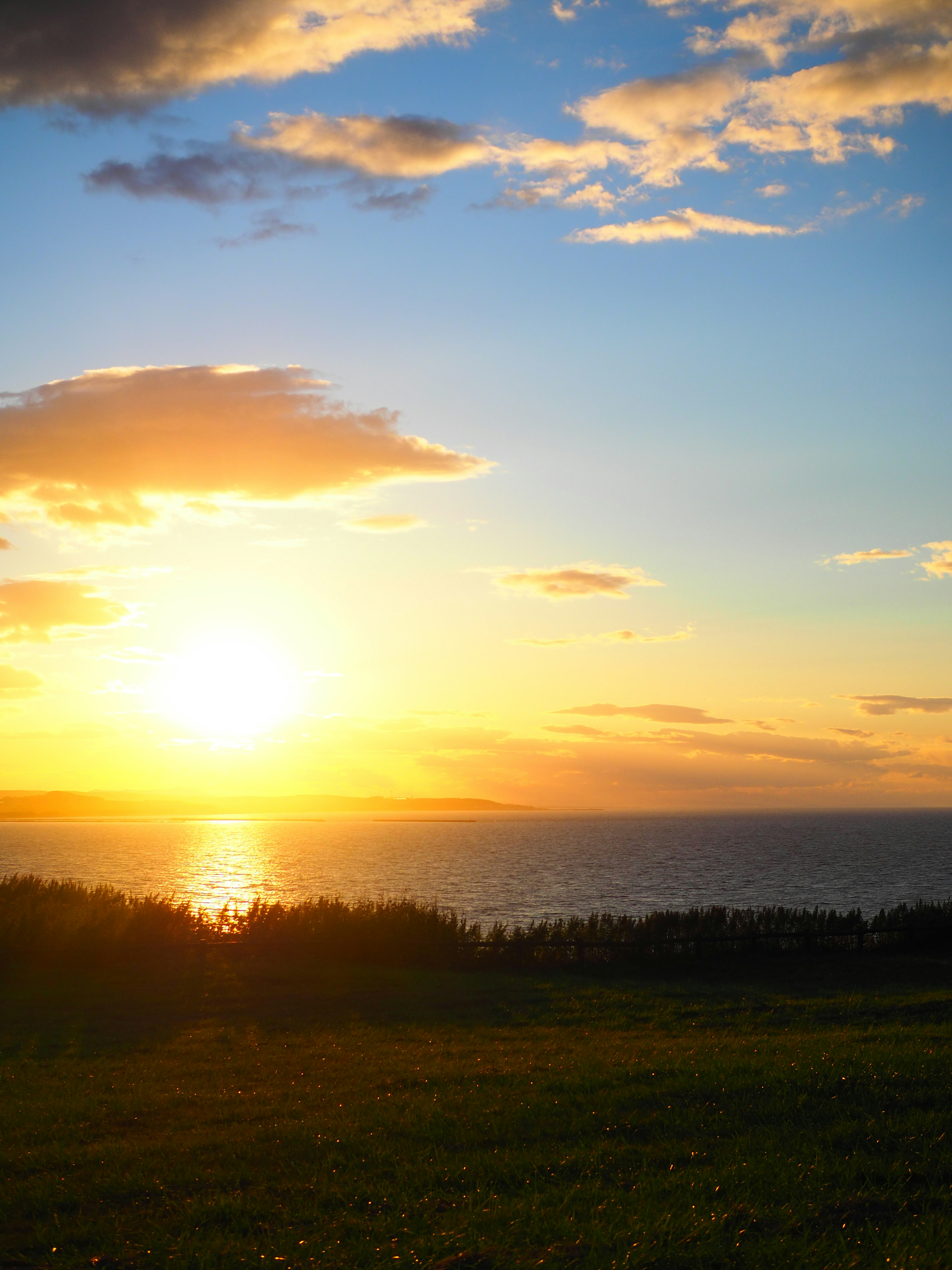 Magnifique coucher de soleil sur l'océan avec des nuages dans le ciel montrant des teintes vibrantes d'orange et de bleu