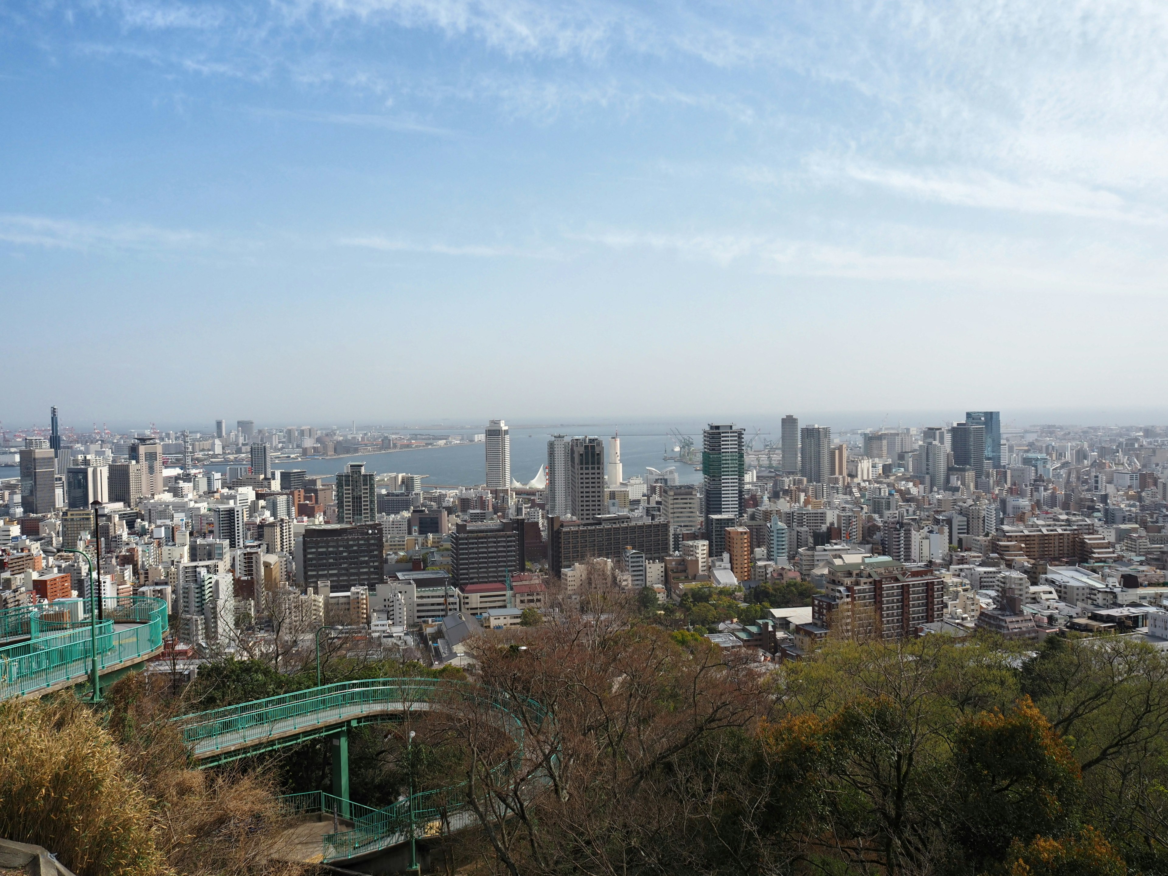 Vista panorámica de una ciudad desde un punto alto con edificios y el mar