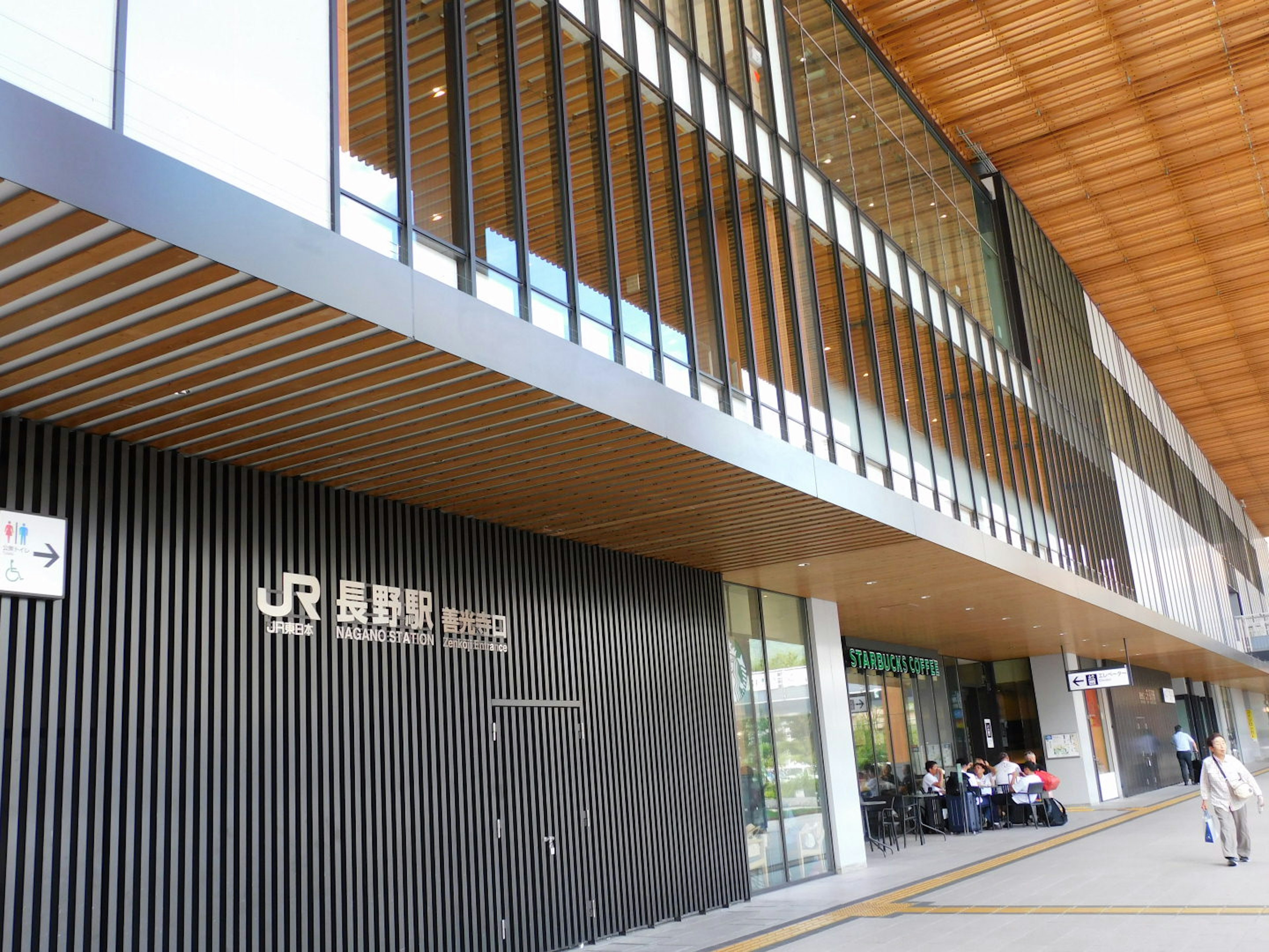 Exterior moderno de la estación JR con techo de madera