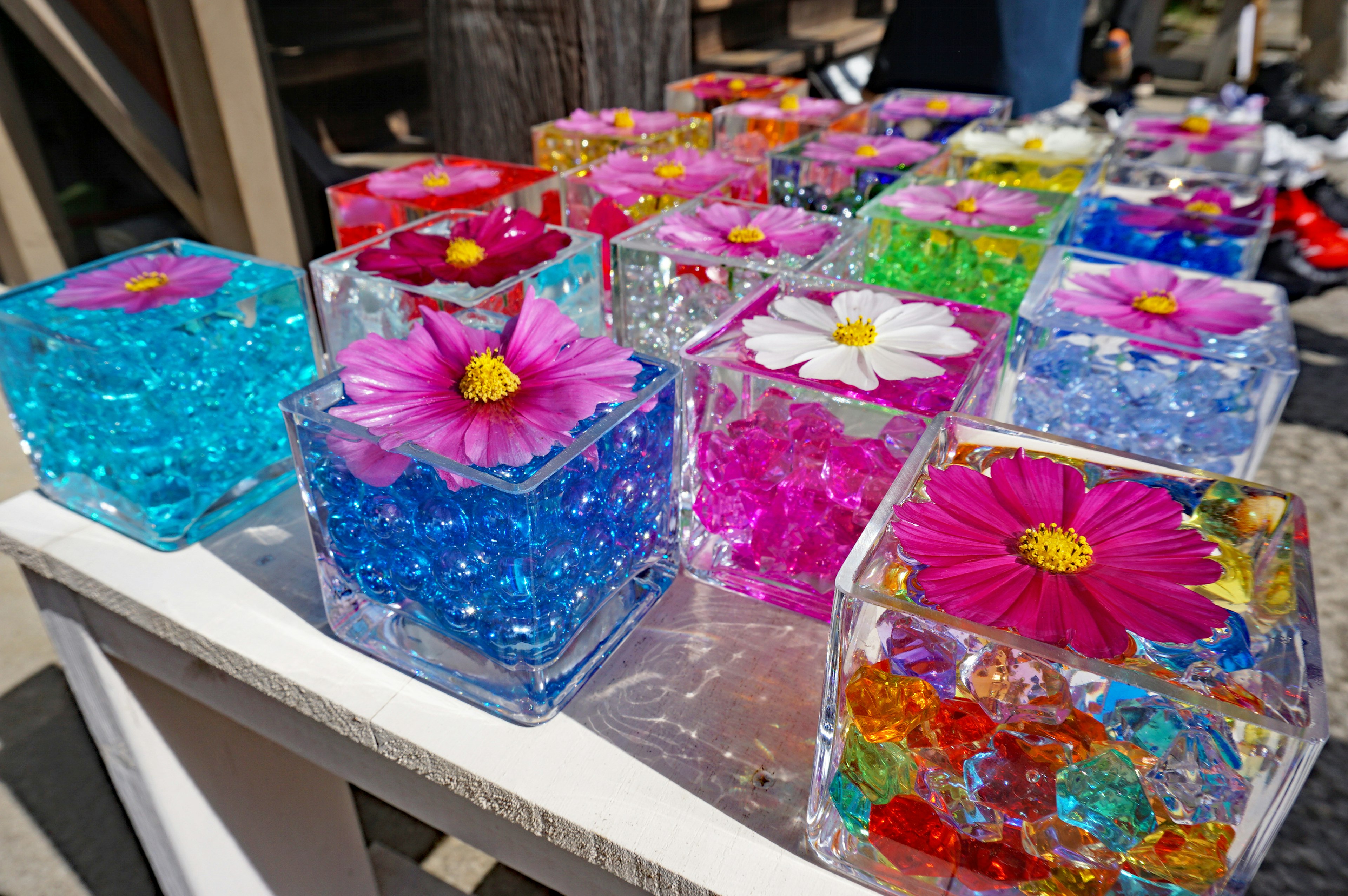 Cubes d'art colorés avec des fleurs et des perles exposés à l'extérieur