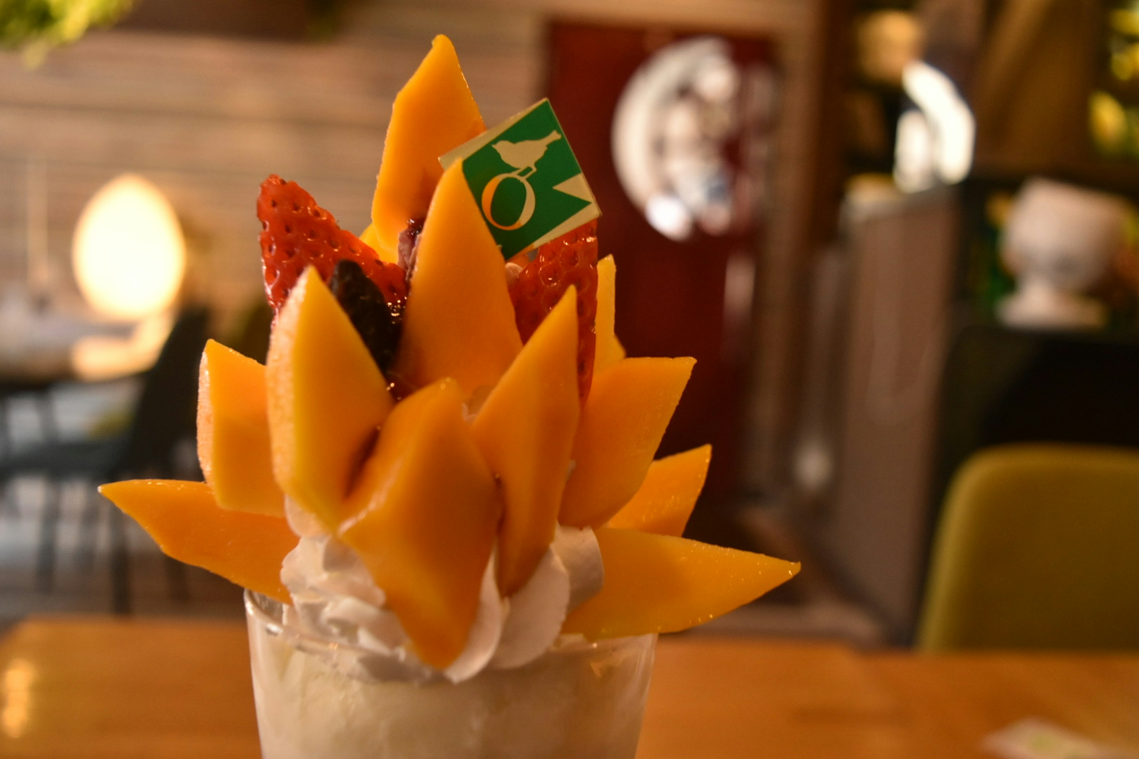 Postre decorado con frutas coloridas, incluyendo mango y fresas