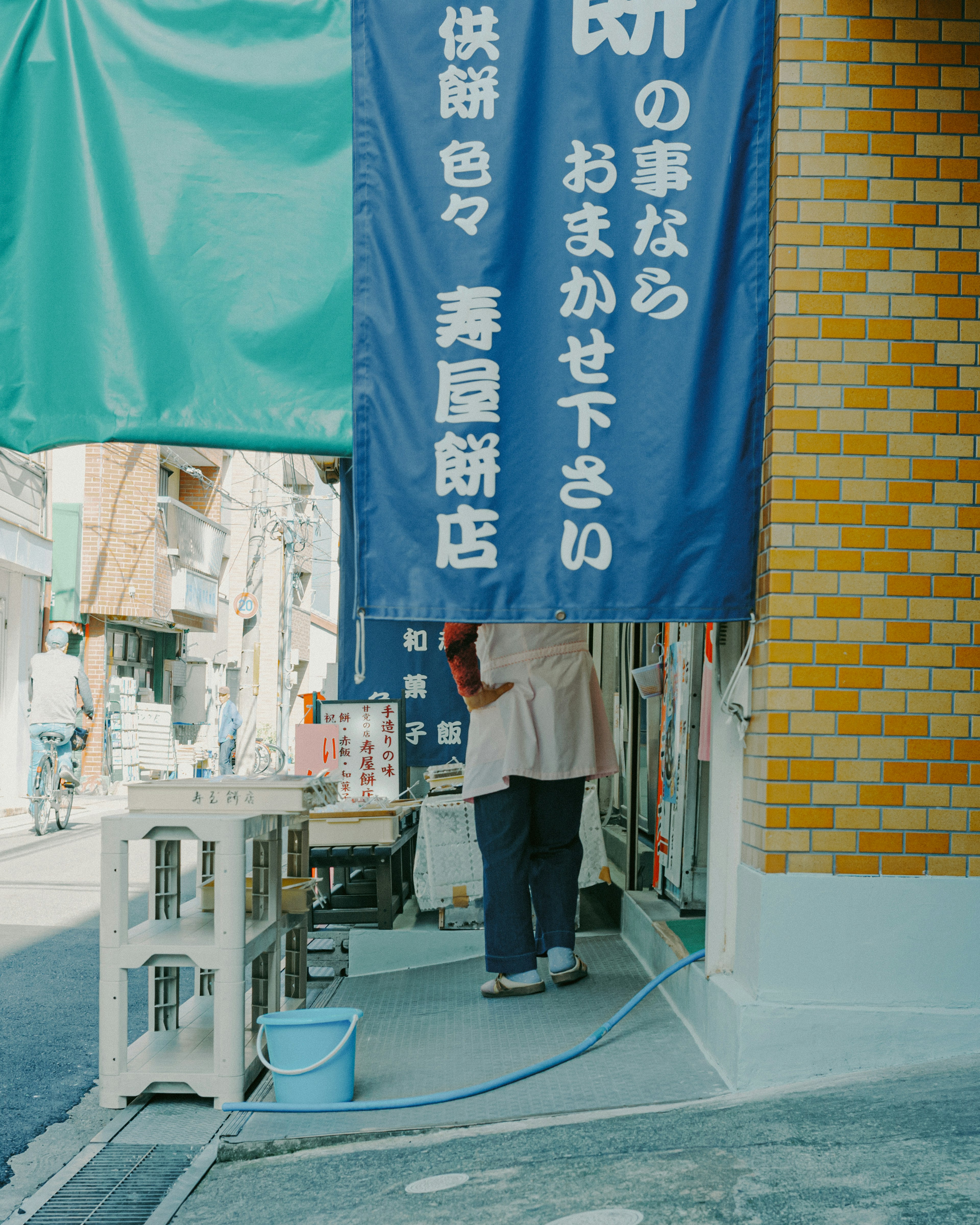 Außenansicht von Aoyaki Mochiten mit einem Schild und einem Mitarbeiter sichtbar