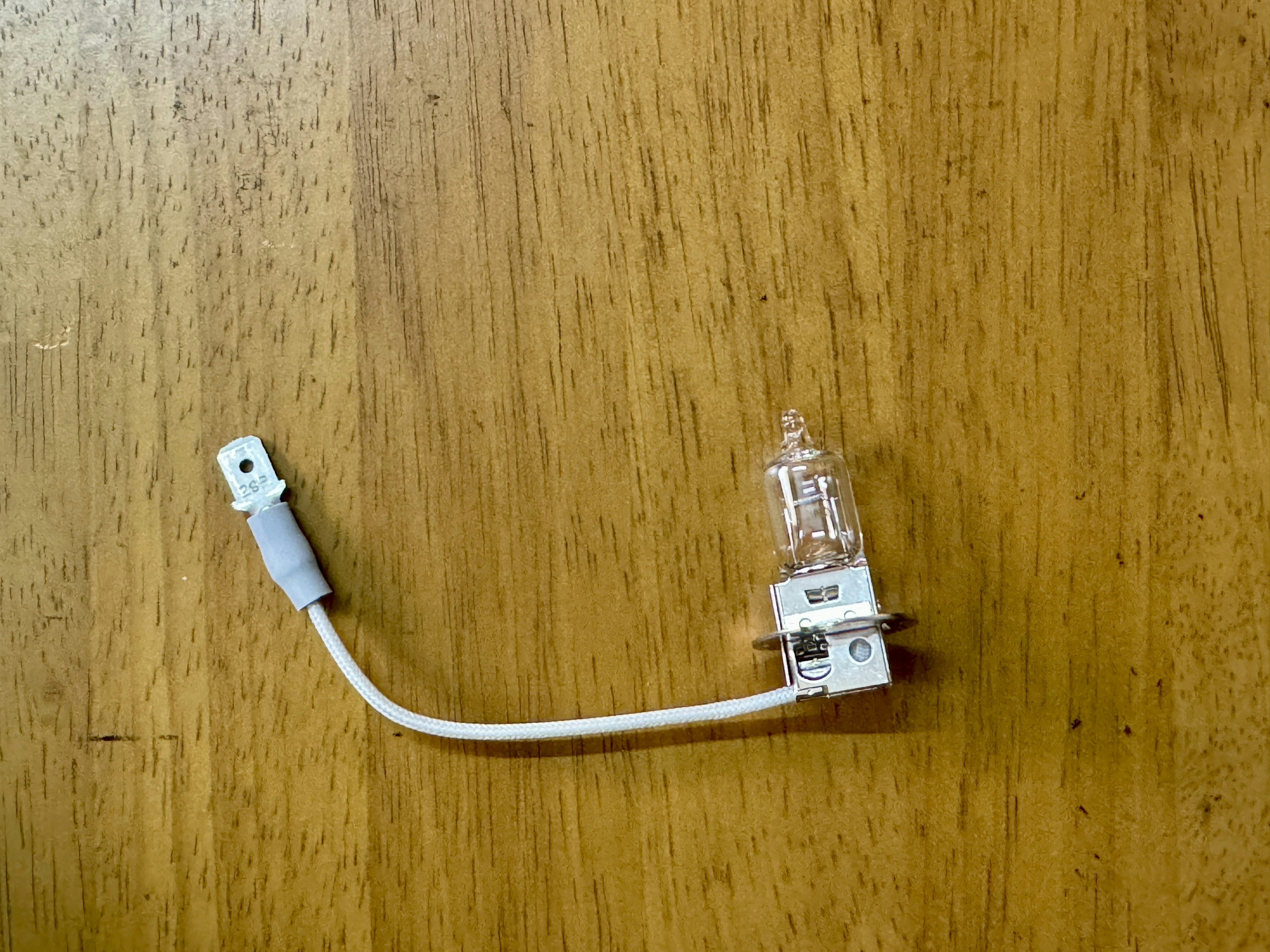 small electrical component with white wiring and a transparent bulb