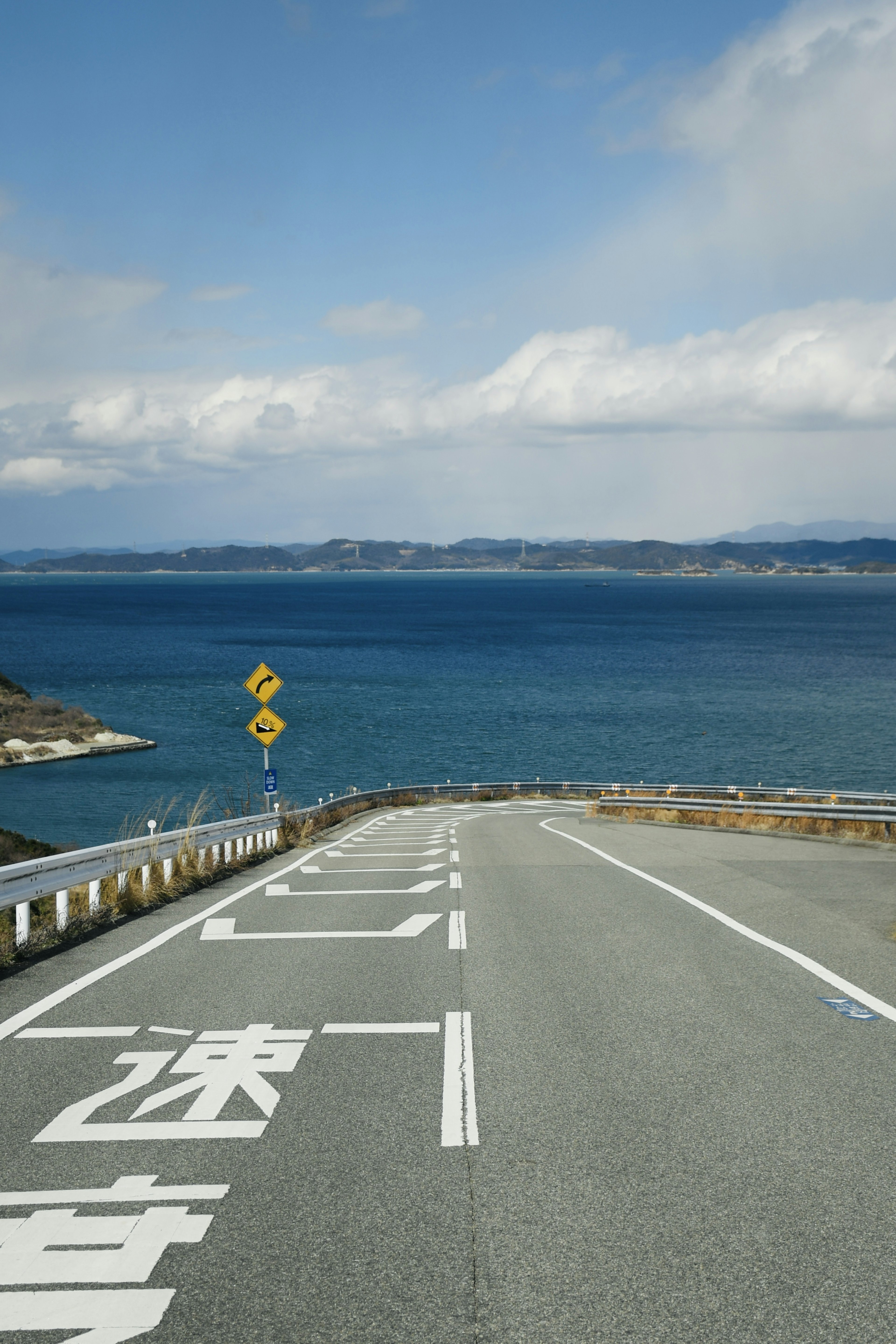 Scenic road view by the sea blue sky with clouds