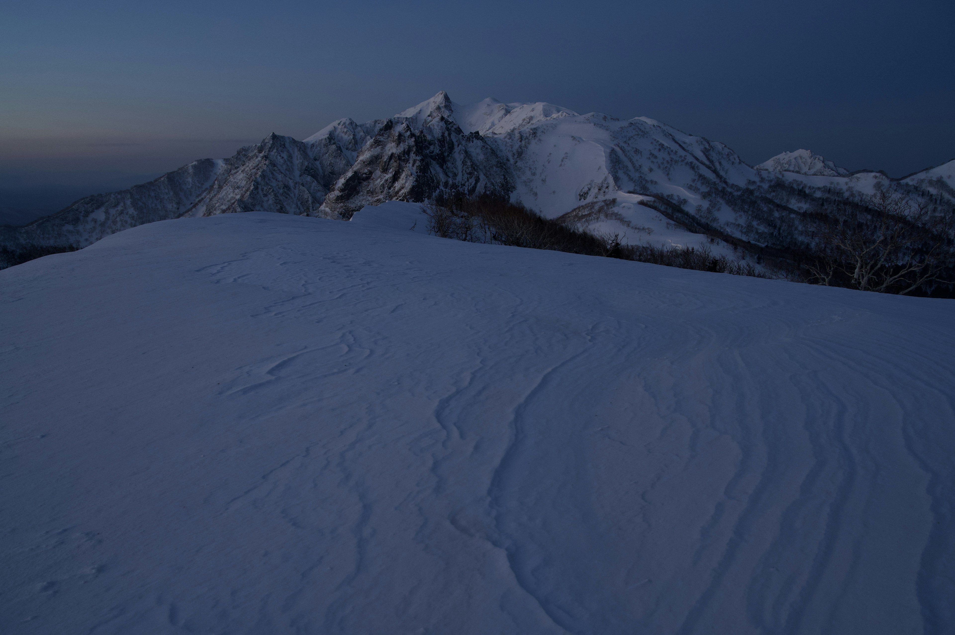 Snow-covered mountain landscape with a blue sky