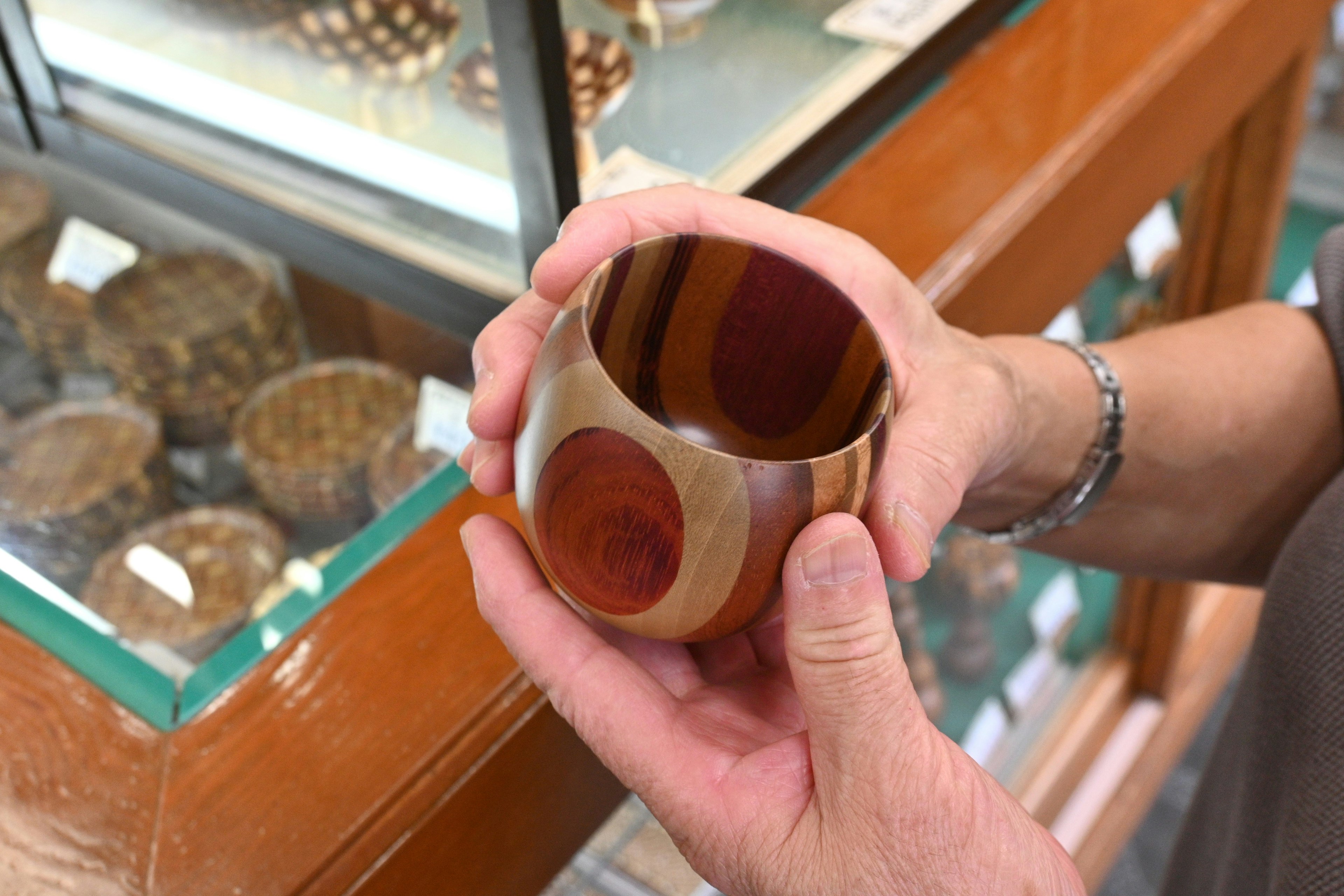 Una hermosa taza de madera sostenida en las manos Patrones de colores únicos y un interior de tono profundo