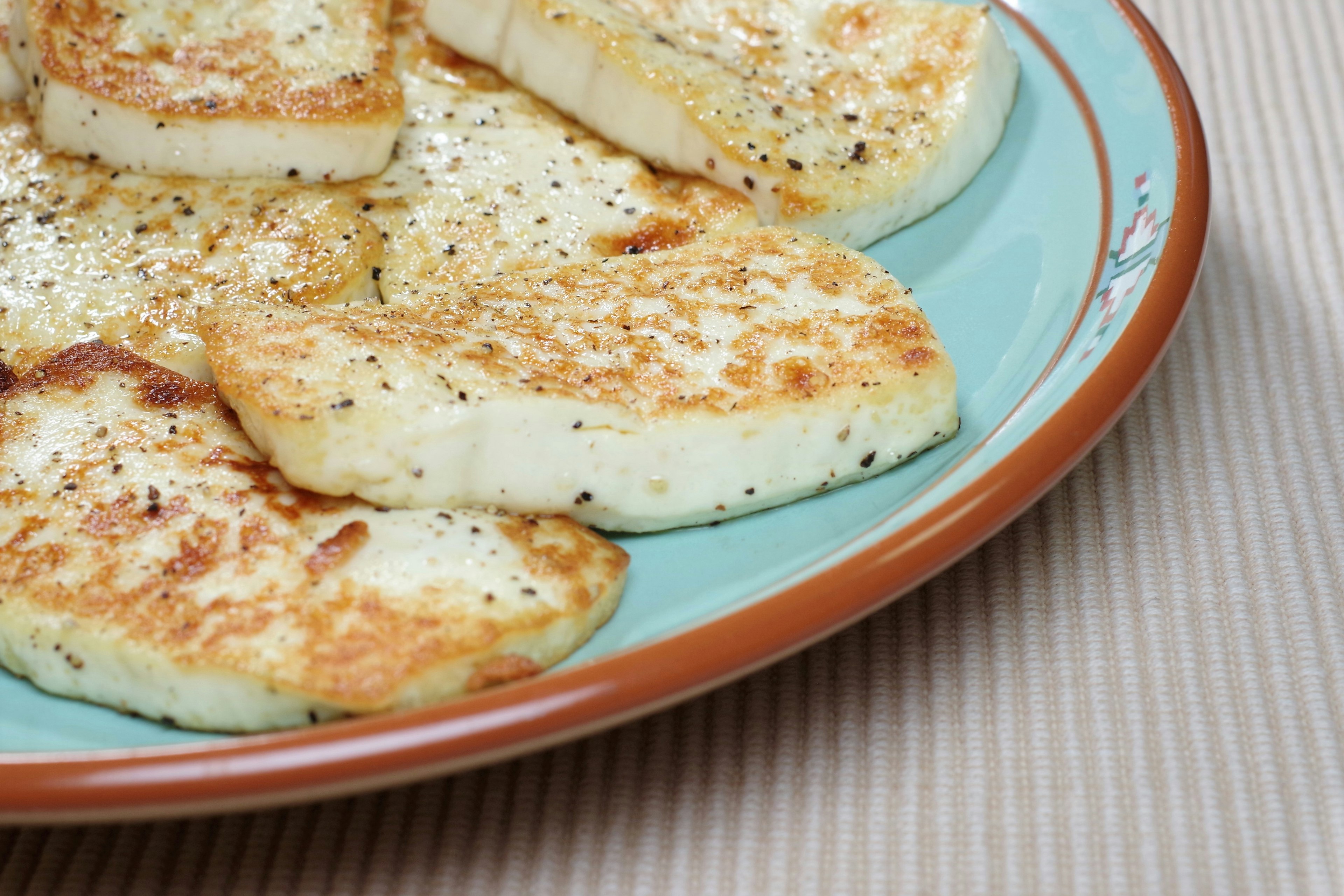 Gegrillte Halloumi-Käsescheiben auf einem blauen Teller serviert