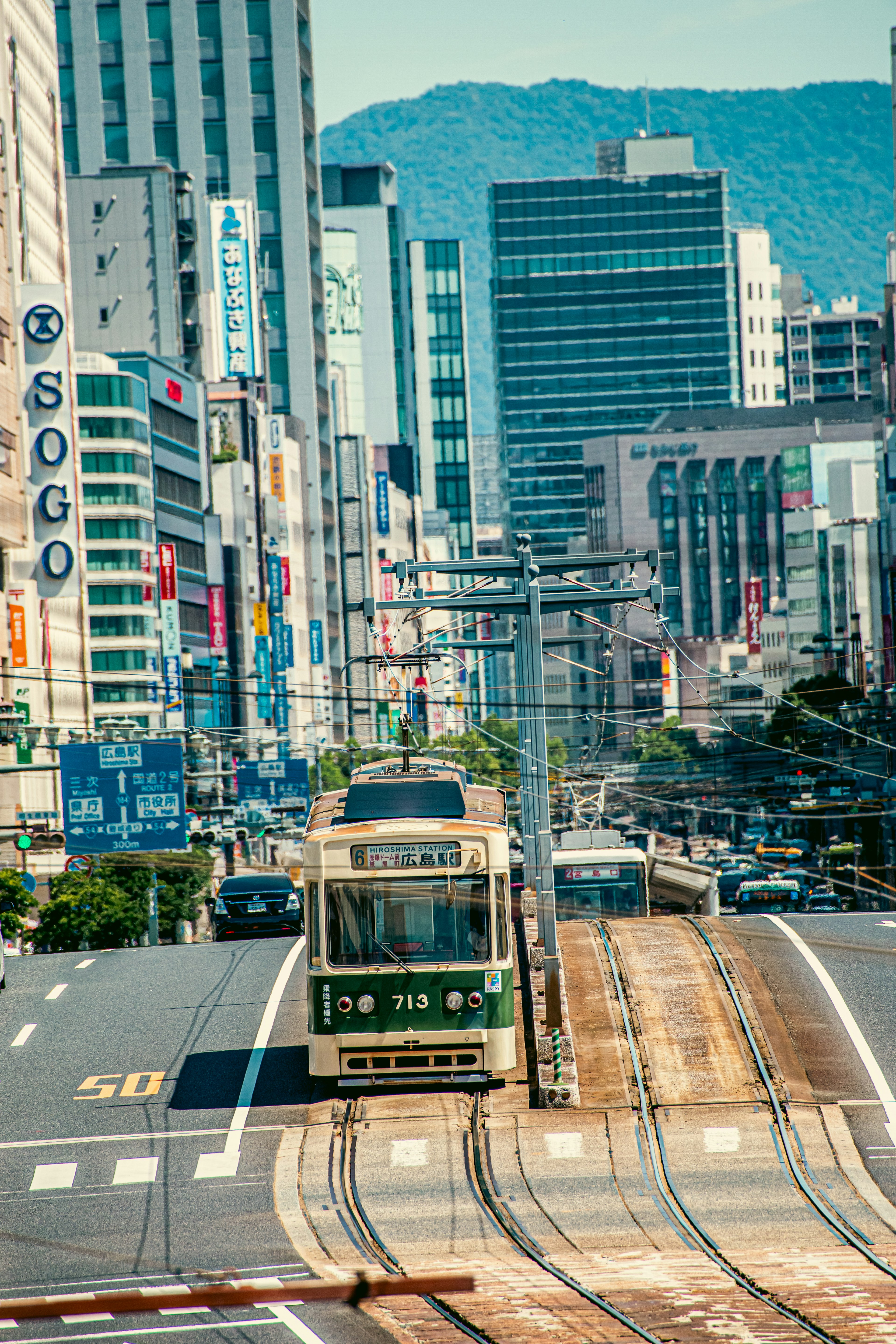 Urban tram scene with buildings and blue mountains in the background