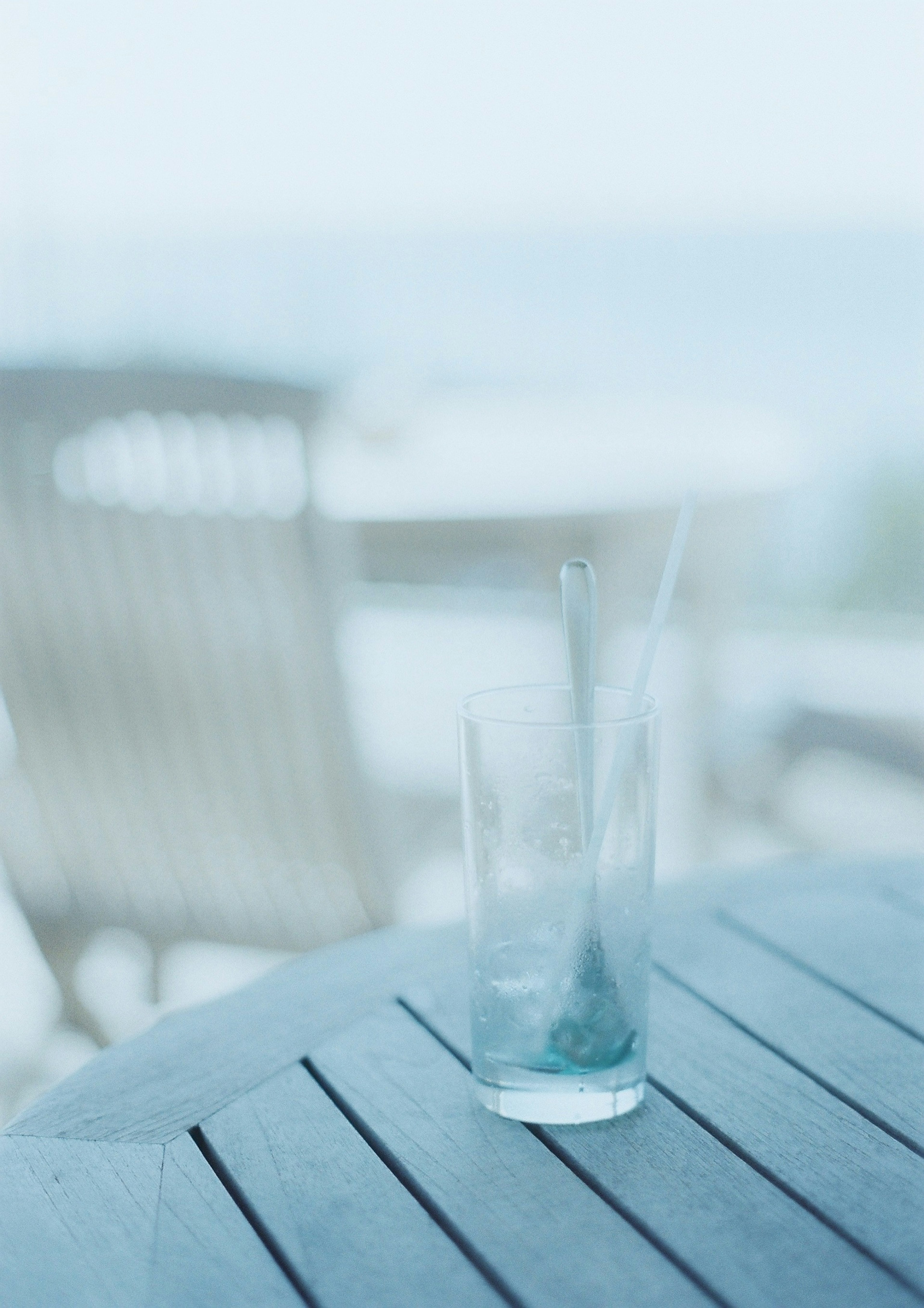 Verre transparent sur une table avec un arrière-plan océan bleu