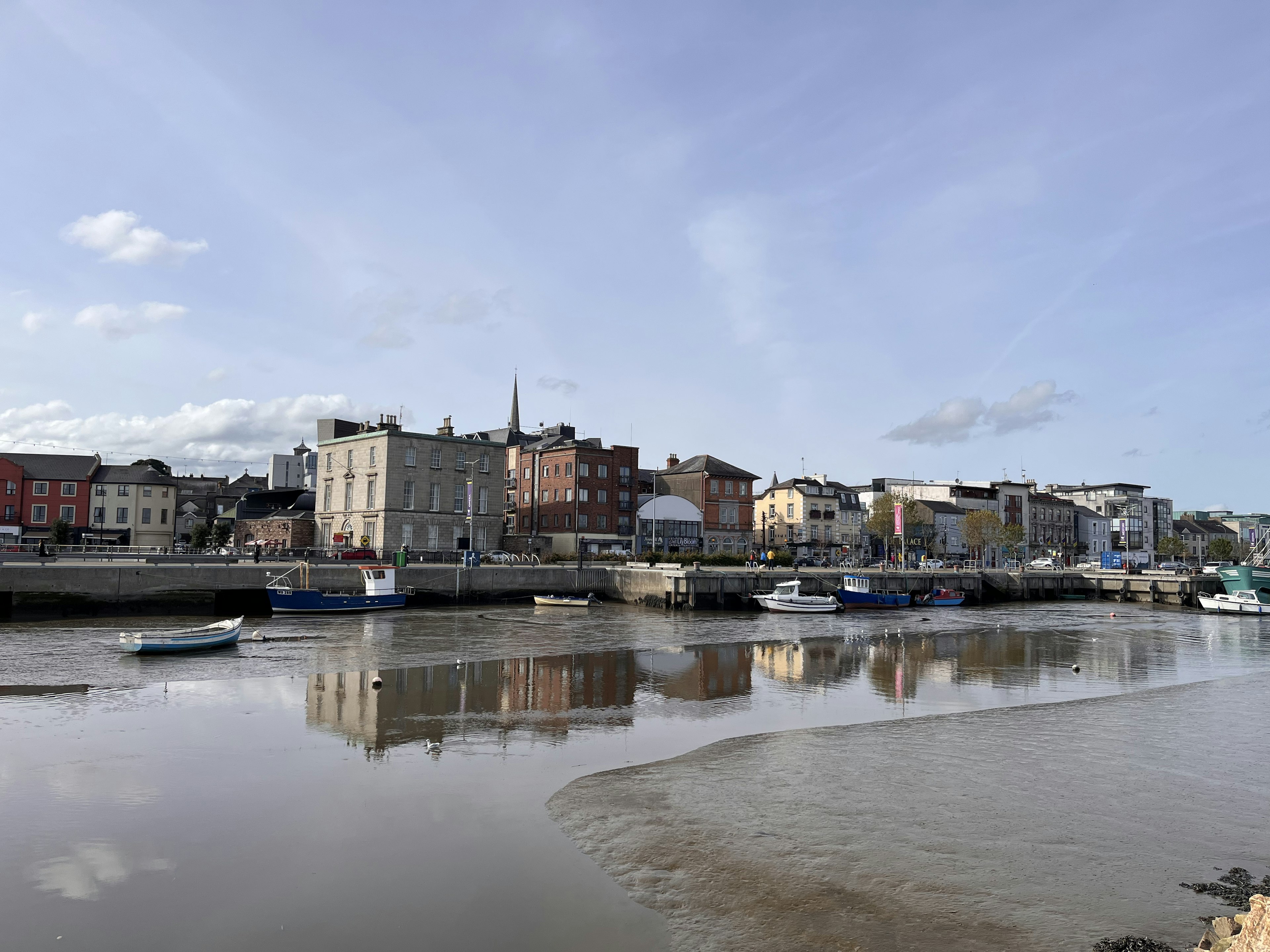 Stadtansicht mit Flussreflexionen und ruhigen Wolken