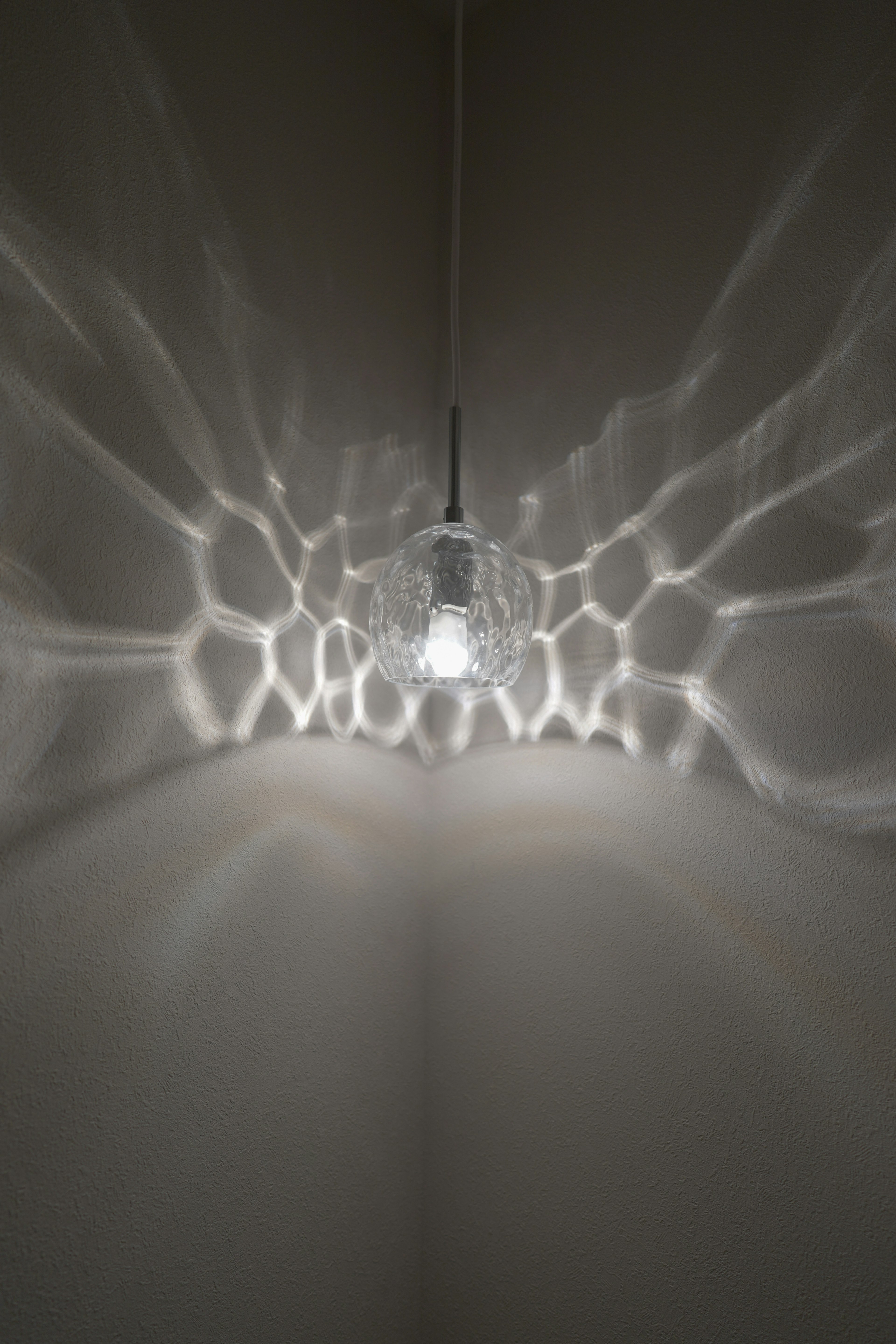 A bright chandelier casting beautiful light patterns on the wall