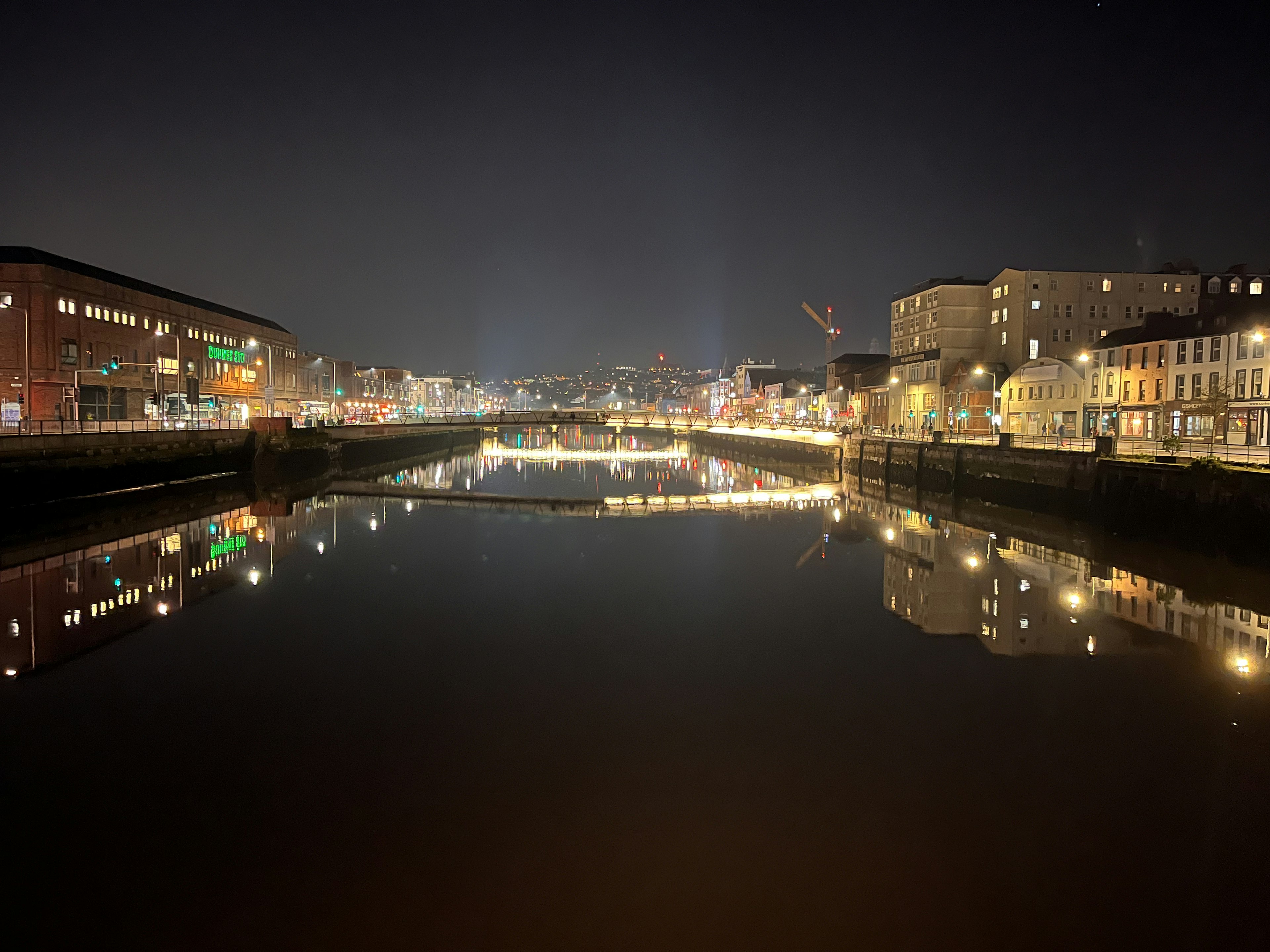 Hermosa vista nocturna de un río y la ciudad con brillantes reflejos y agua tranquila