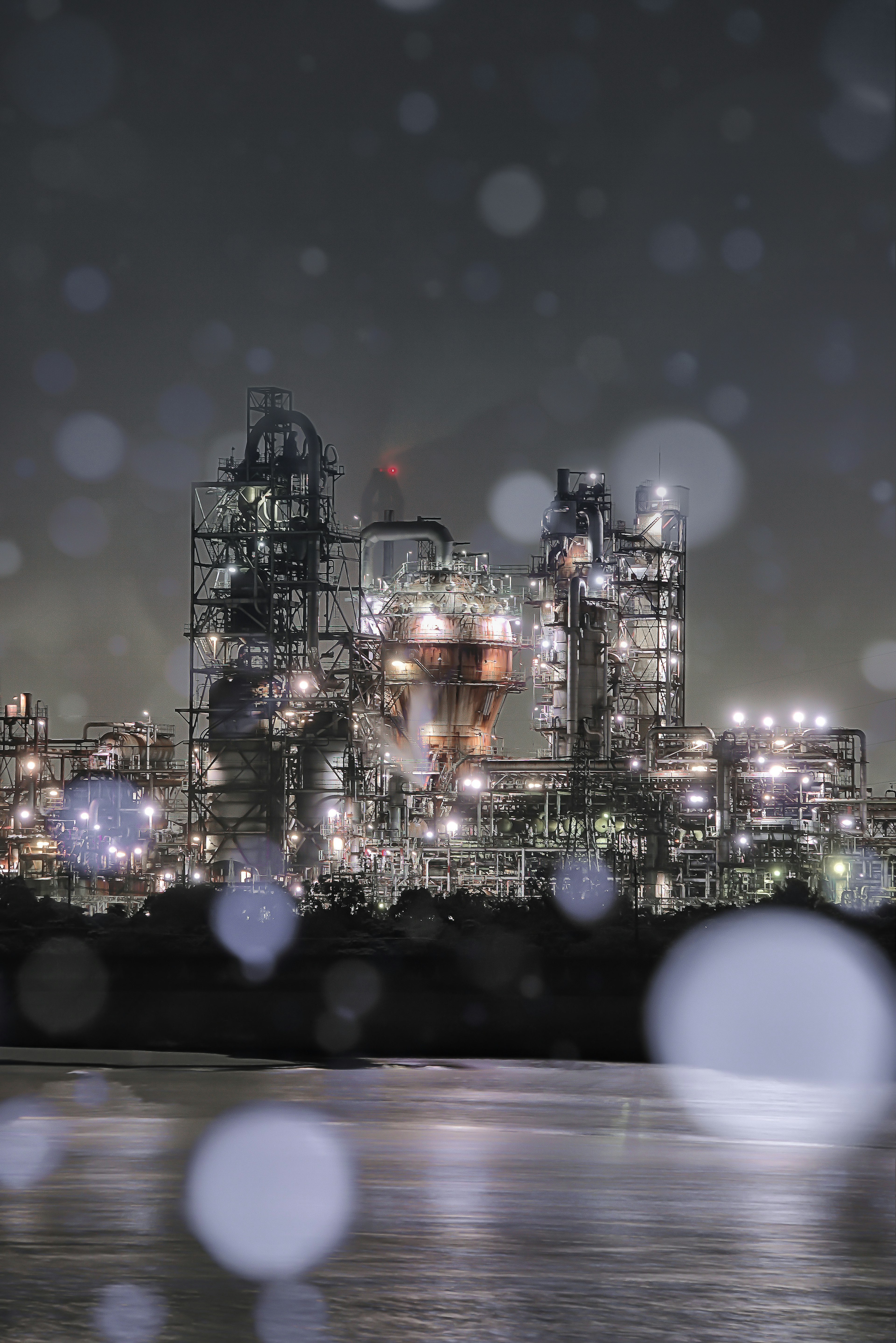 Industrial night scene with blurred snowflakes in the foreground