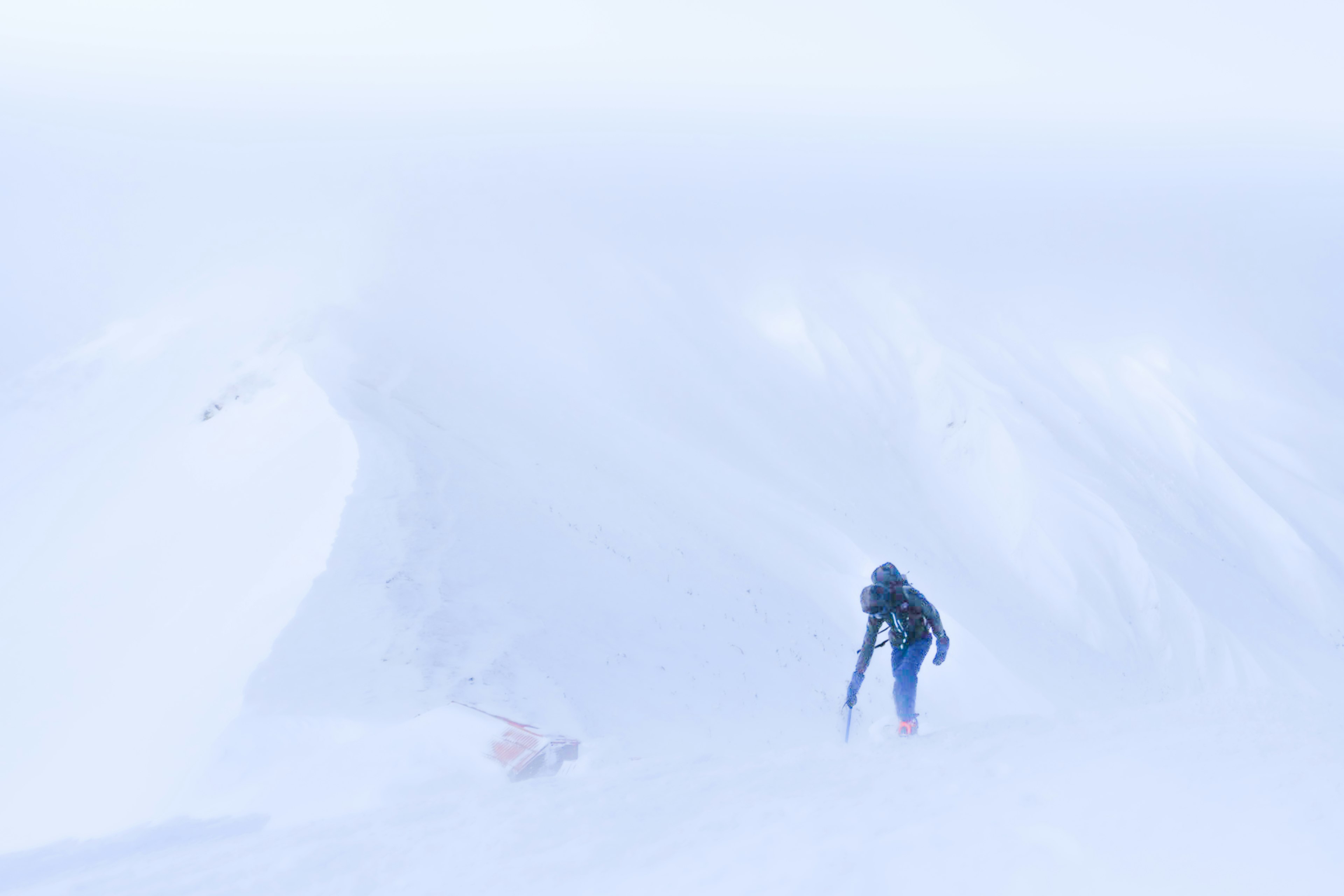 Person climbing in snow and fog