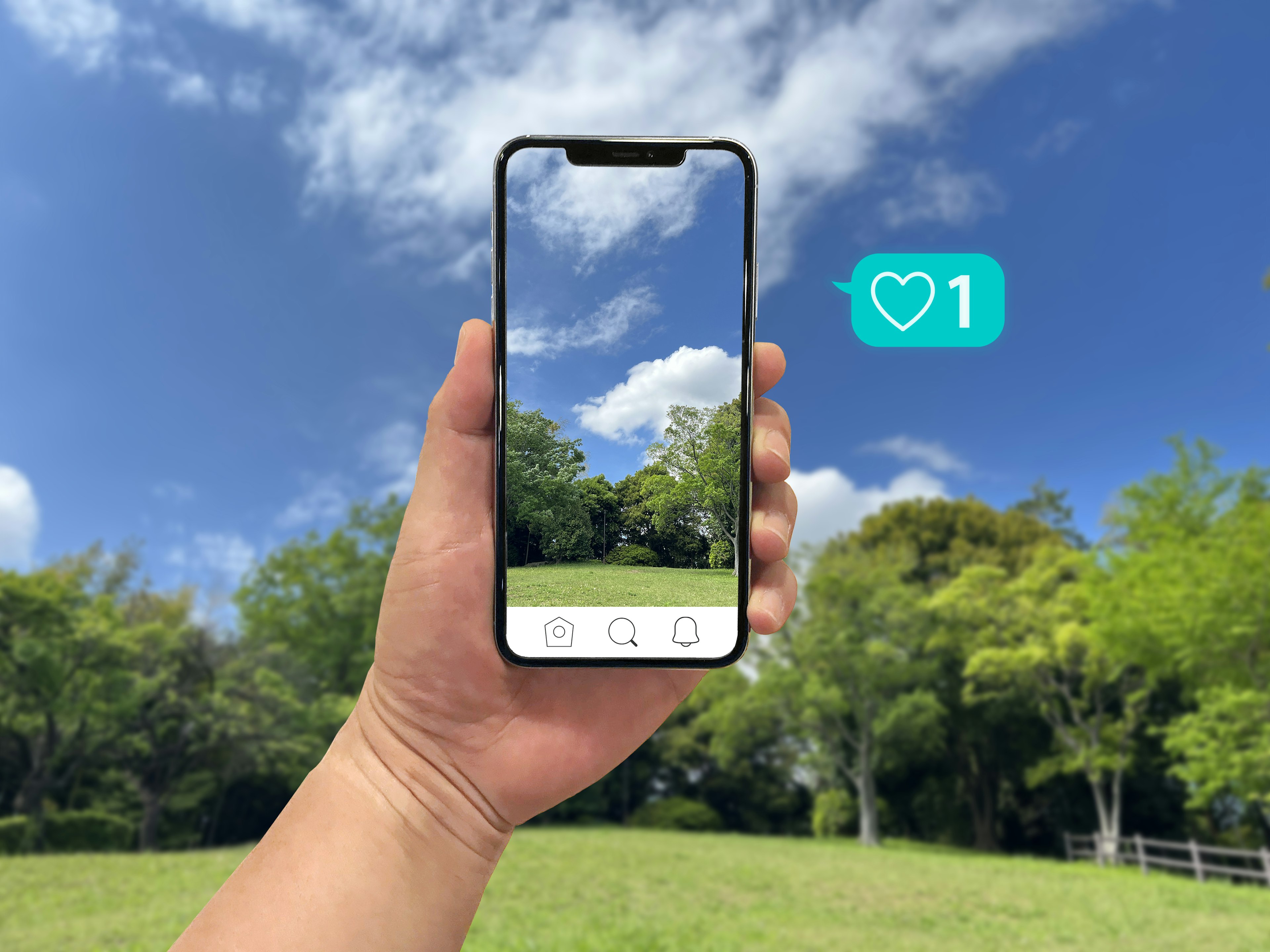 Eine Hand hält ein Smartphone, das einen blauen Himmel und grüne Bäume zeigt