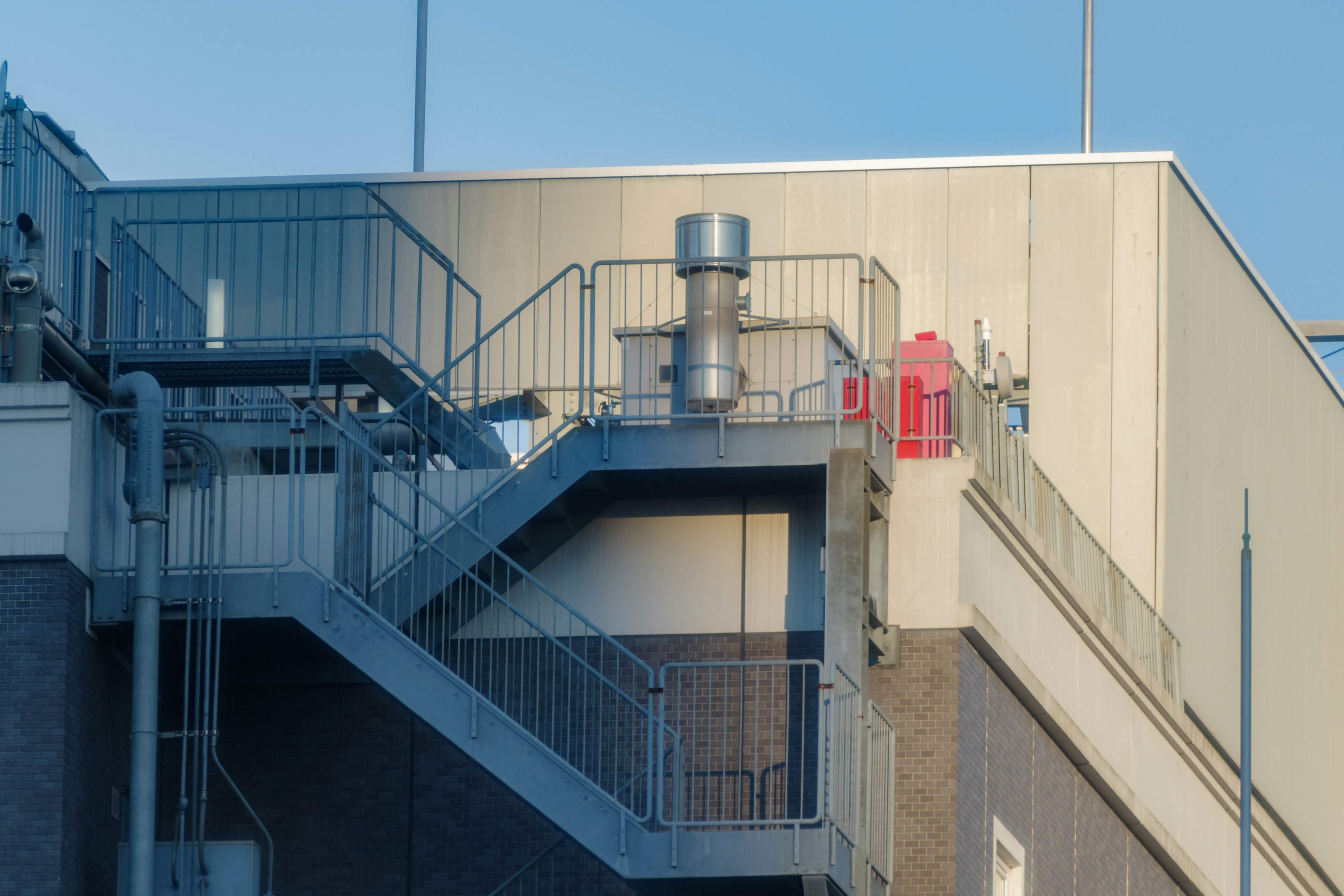 View of rooftop with staircase and exhaust duct