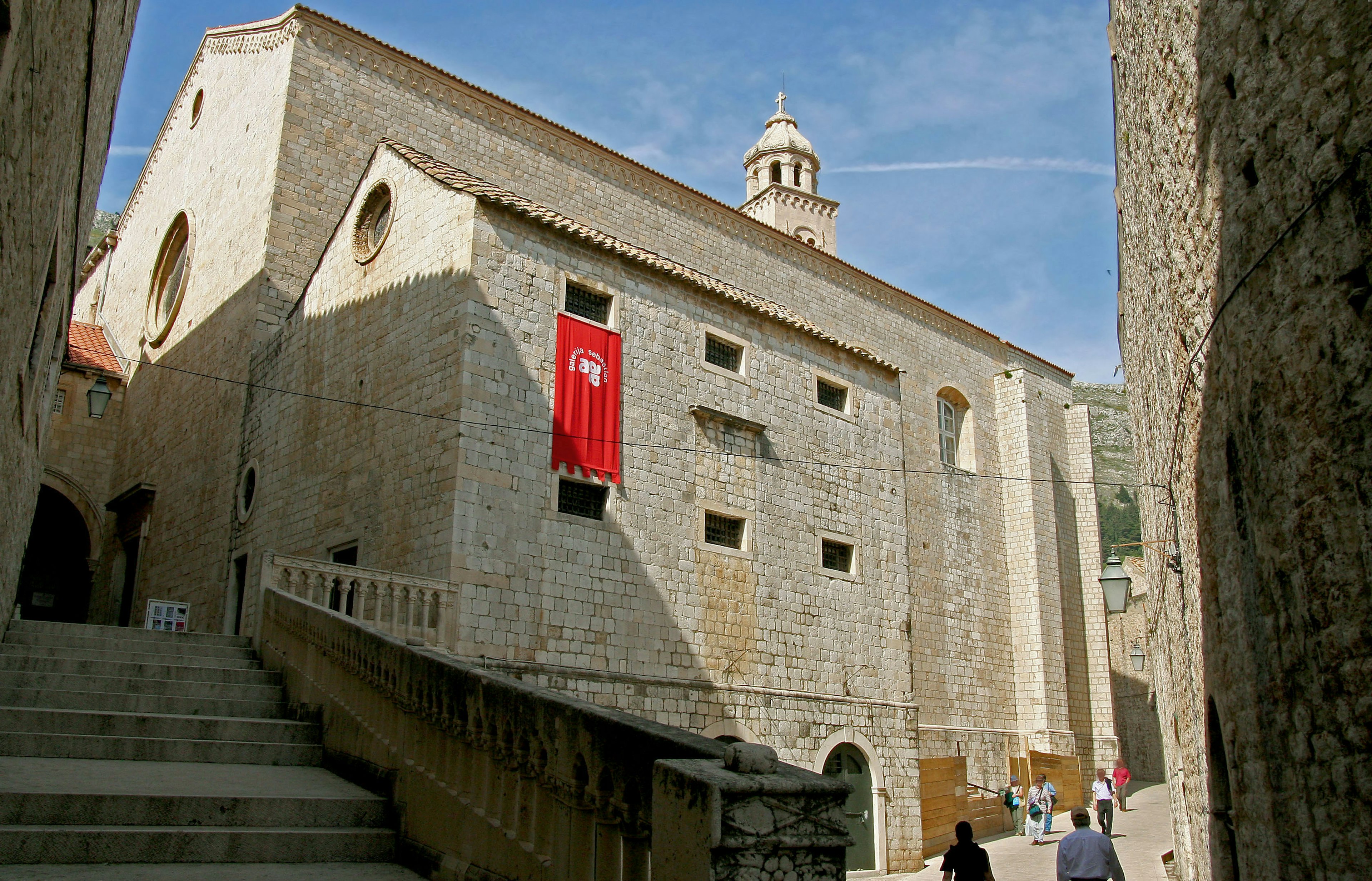 Medieval stone building with a red banner and blue sky