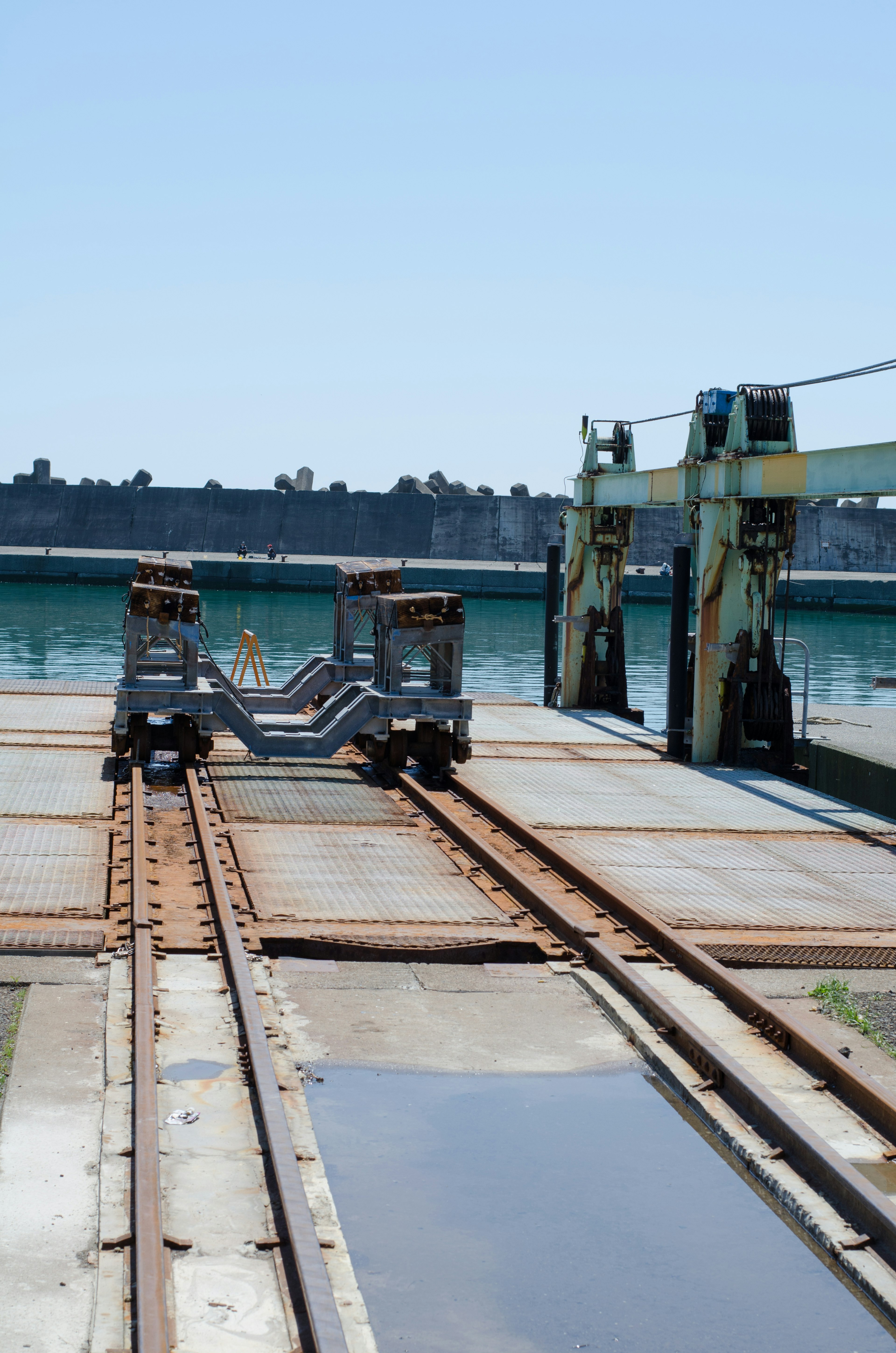 Blick auf eine Eisenbahnplattform am Meer mit Kränen