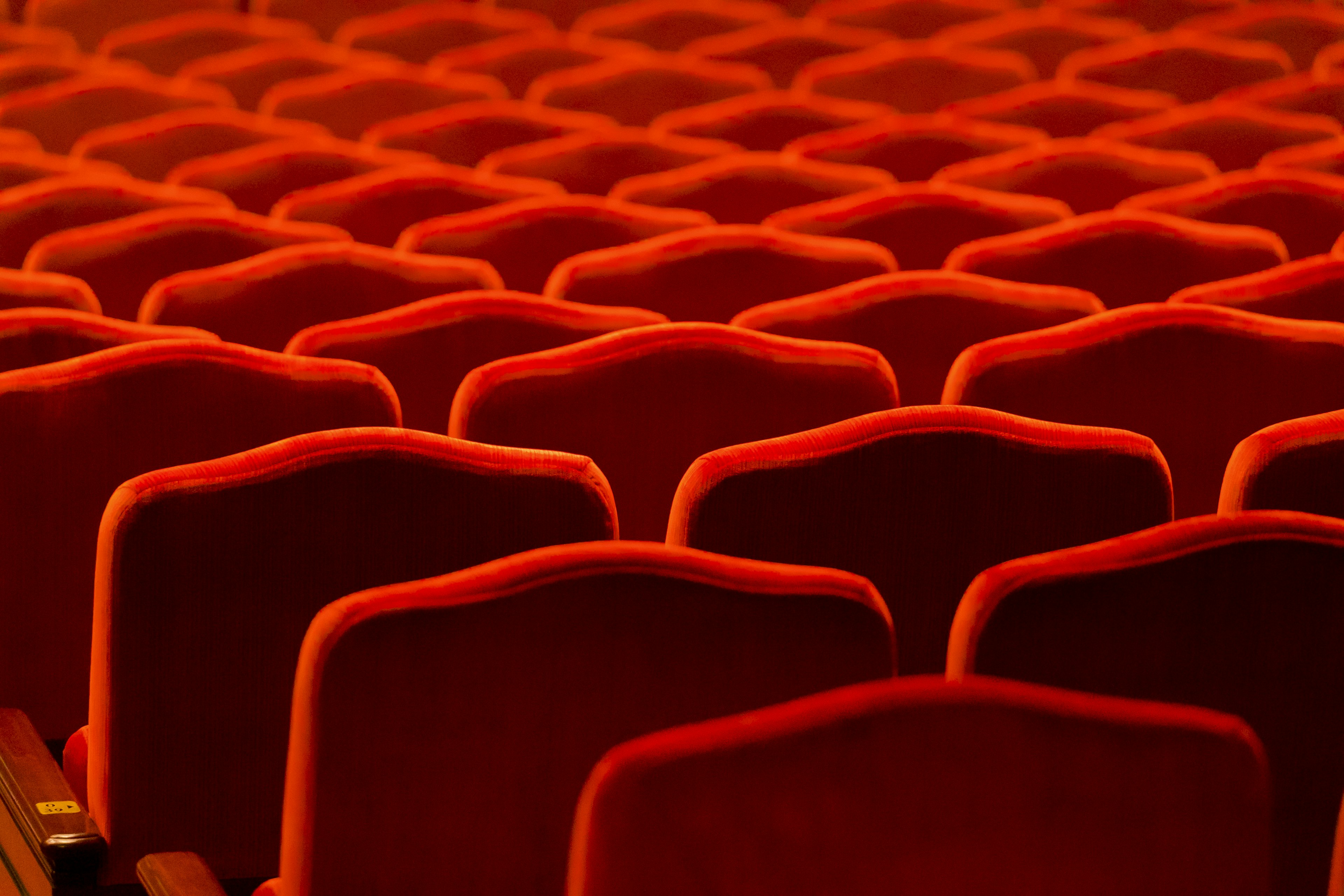 Interior of a theater with neatly arranged red seats