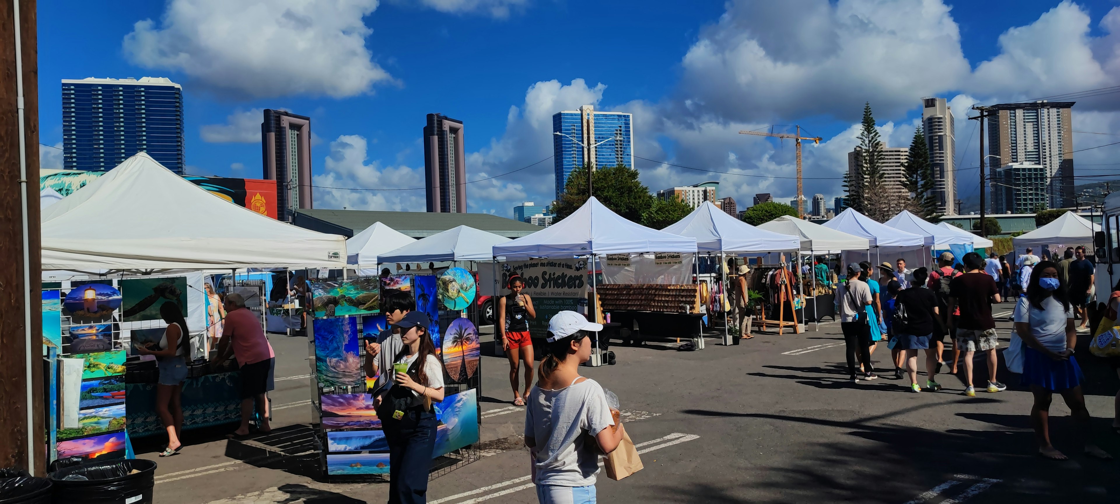 Un mercato affollato con tende e persone sotto un cielo azzurro