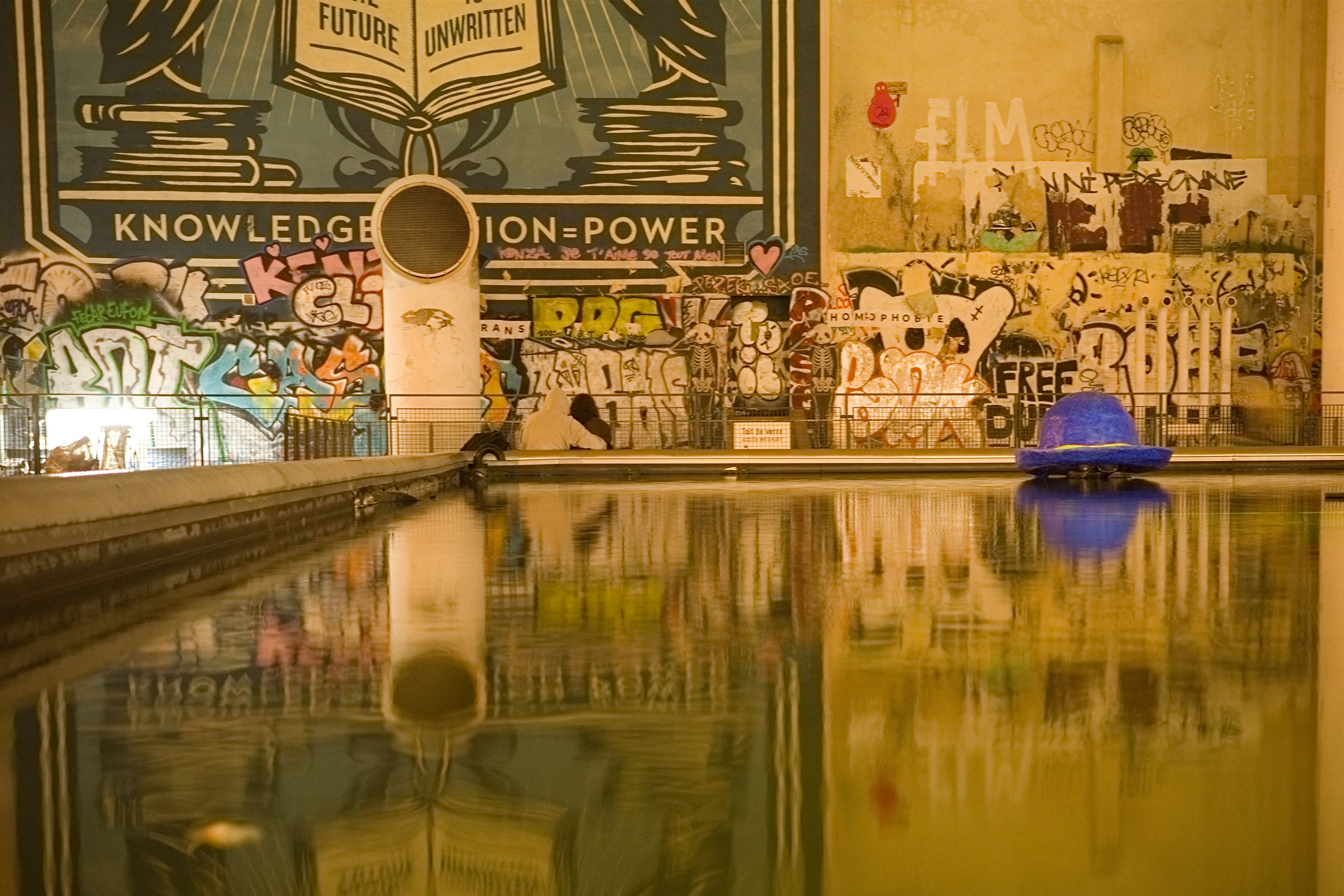 Ruhiger Pool mit Graffiti-Kunst an der Wand, die Wissen als Macht symbolisiert