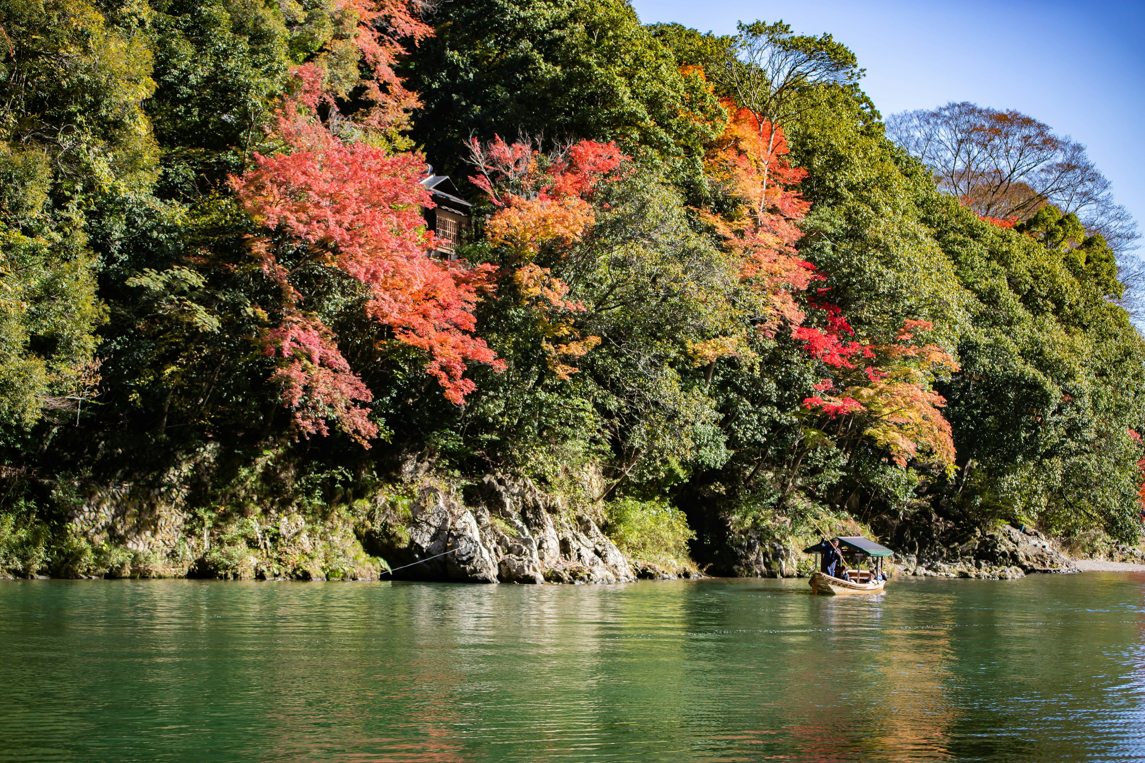 静かな川のほとりの紅葉した木々と穏やかな水面