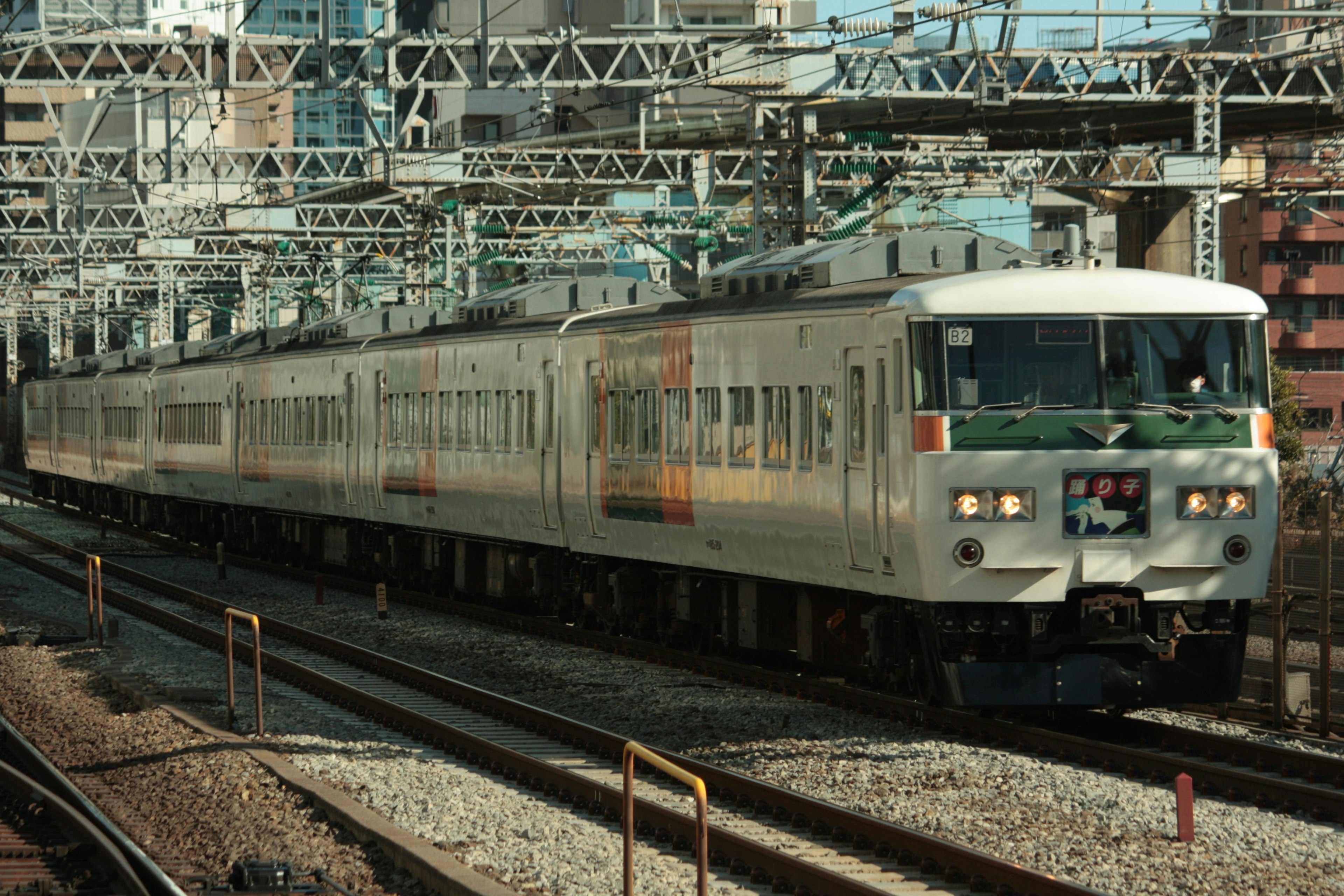 Train in motion at a Japanese station with overhead structures