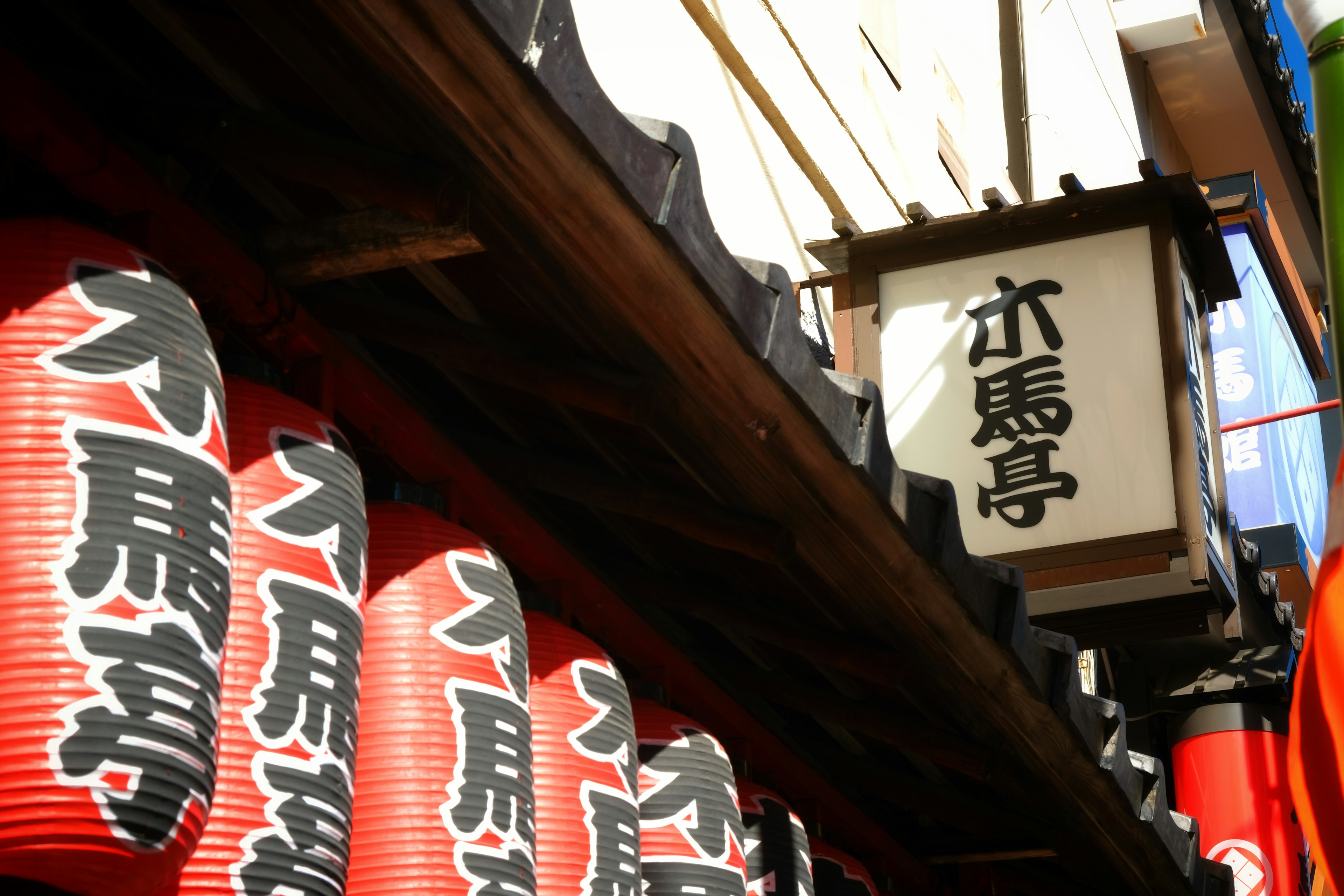 Traditional Japanese shop with red lanterns and a white sign