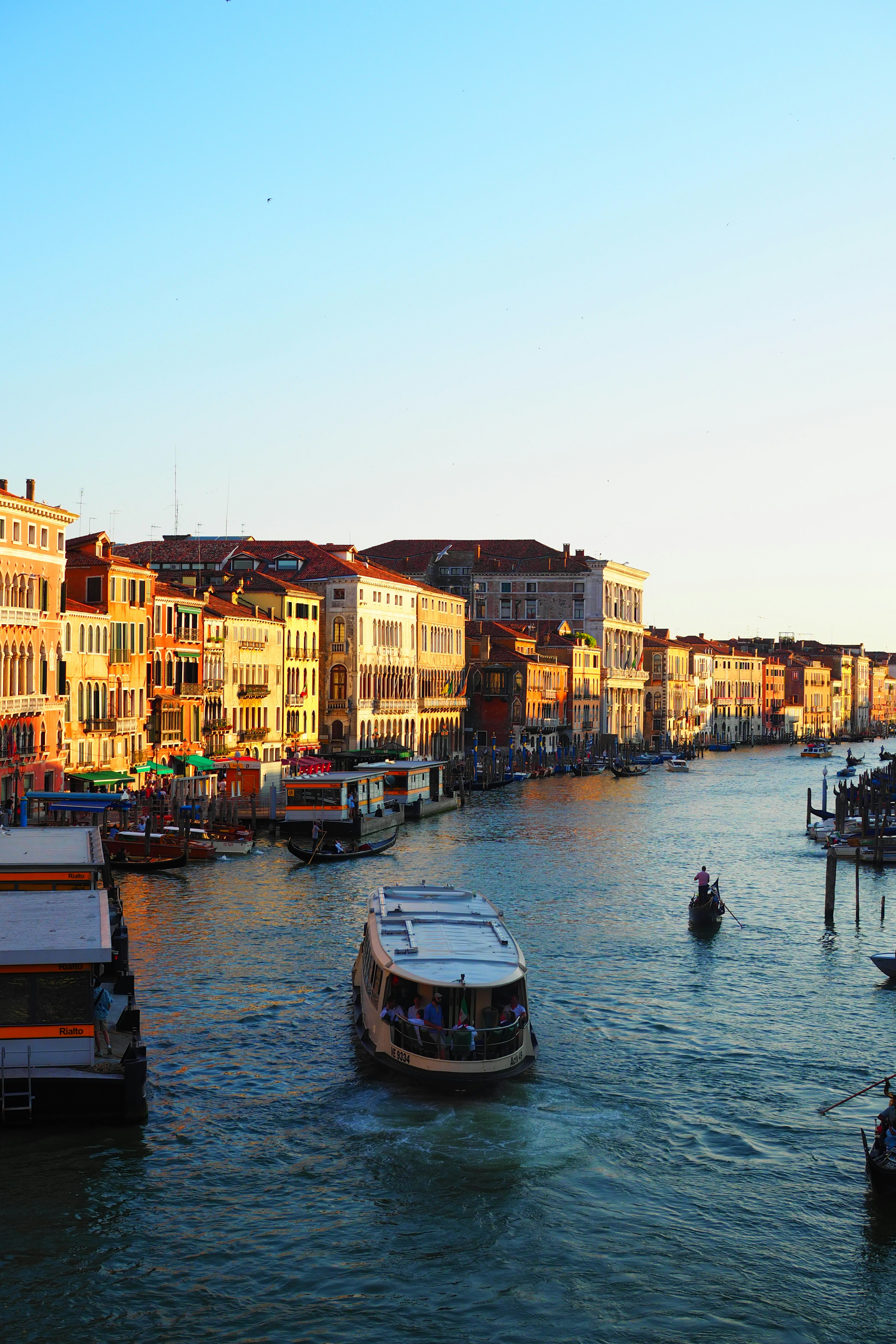 Vue pittoresque de bâtiments le long d'un canal avec un bateau au coucher du soleil