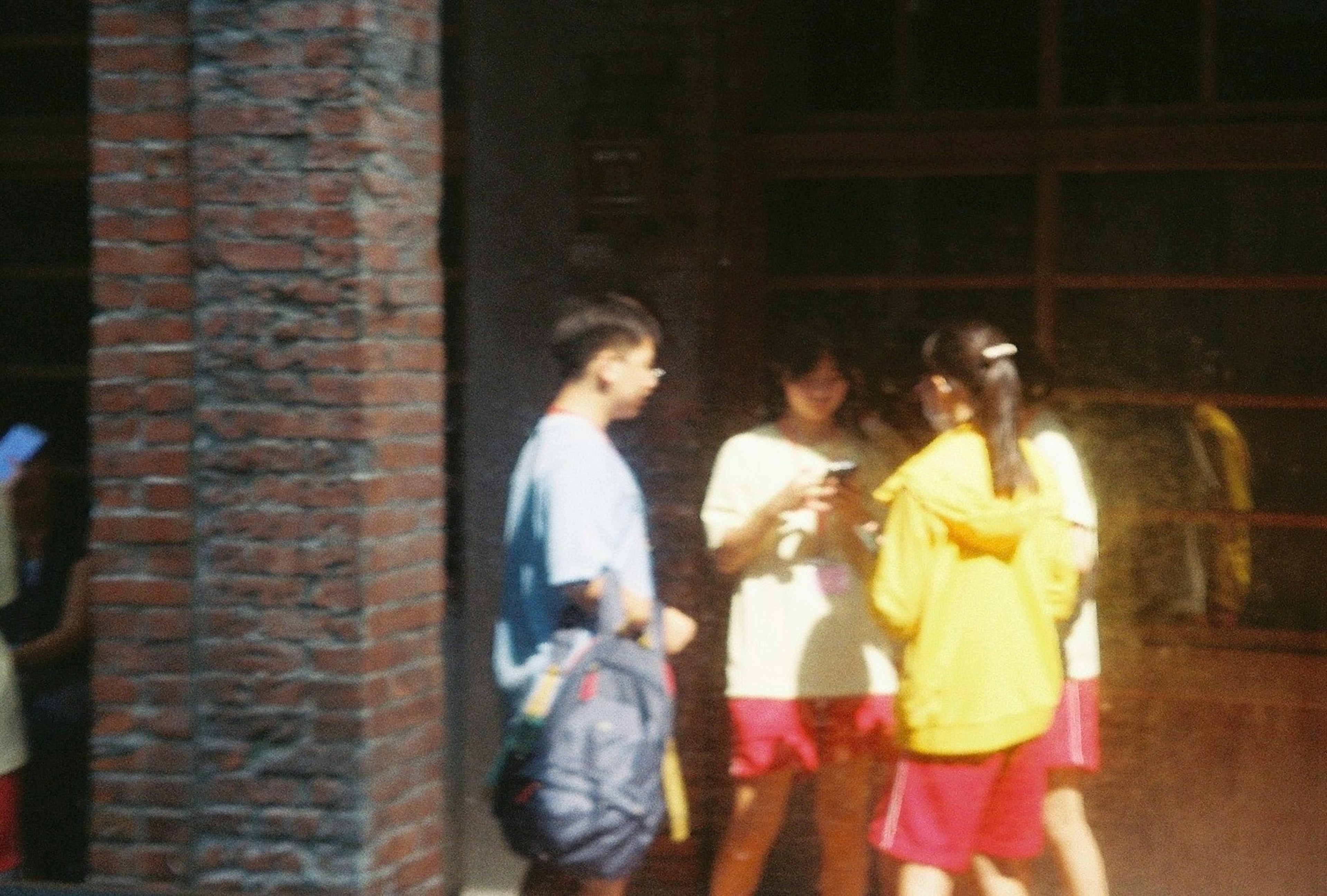 Group of young people in casual clothing talking outside a building