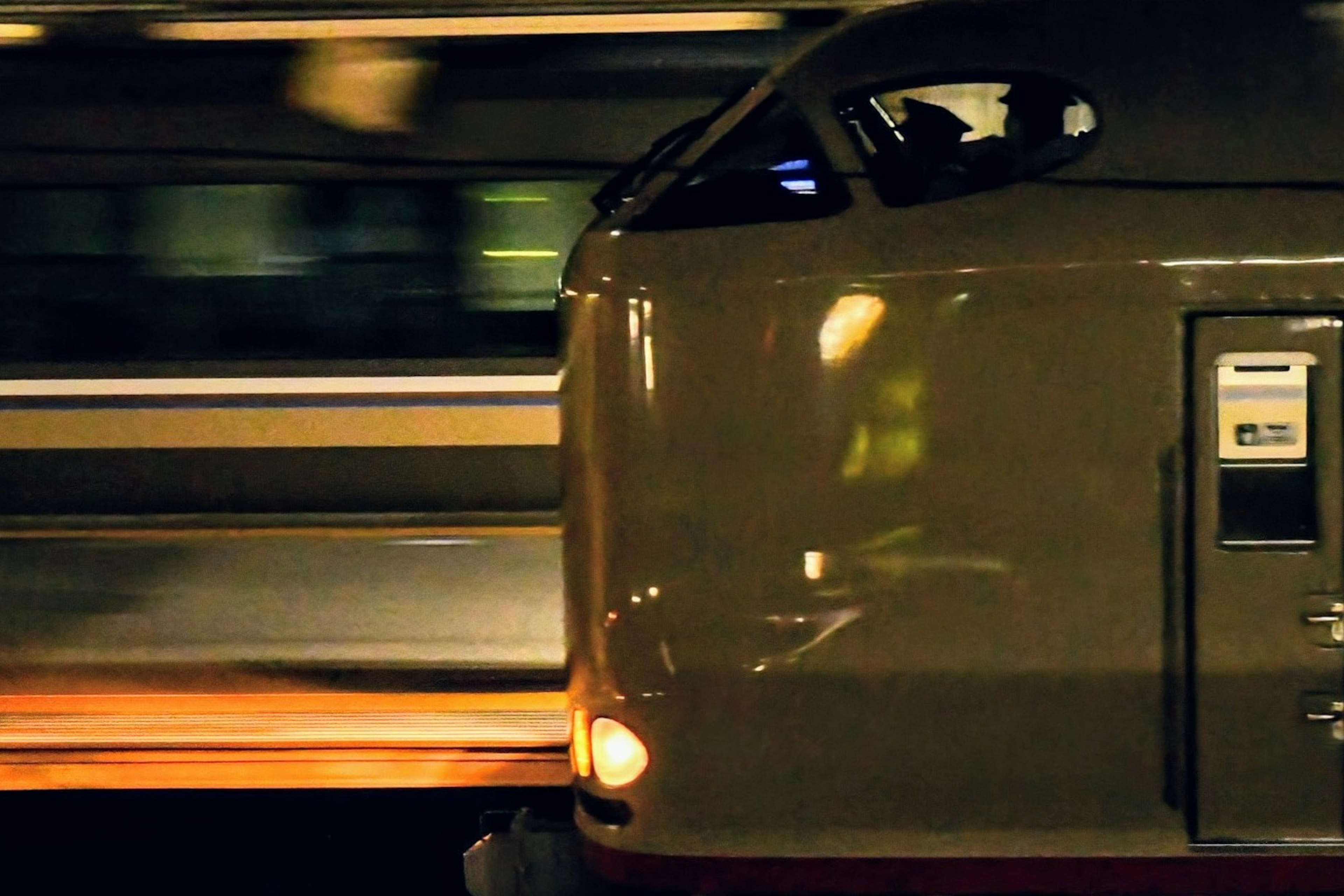 Side view of a Shinkansen speeding through a night scene