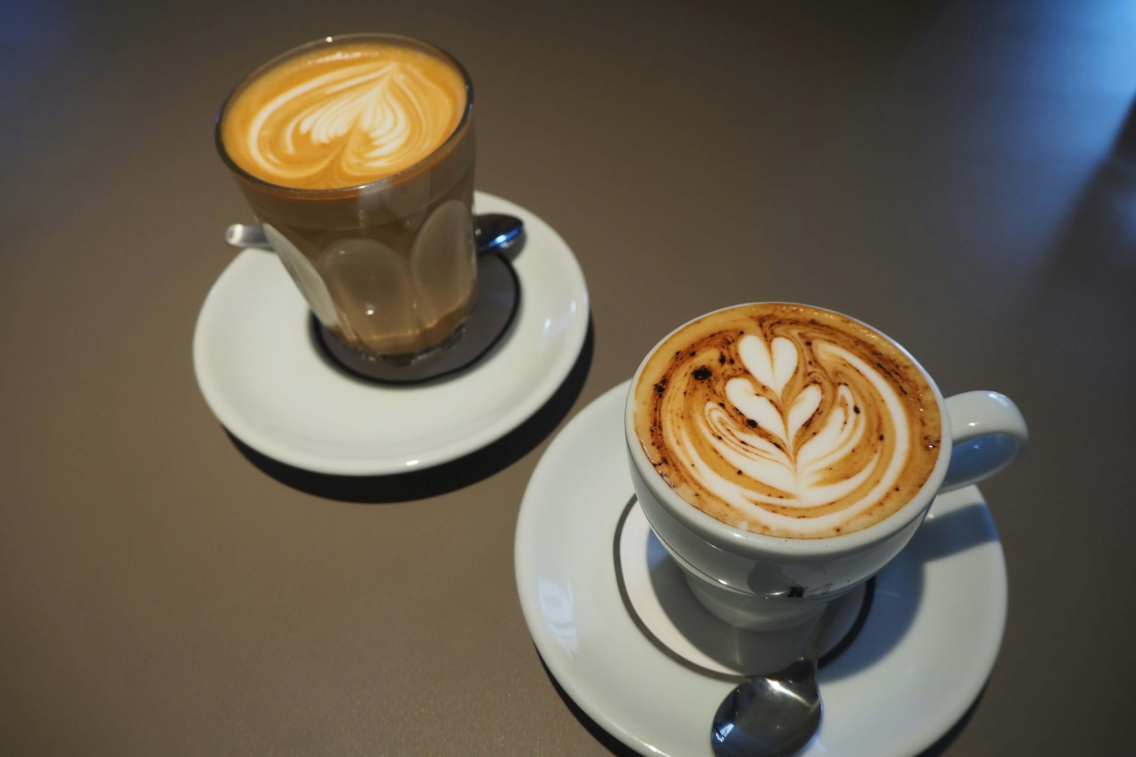 Two coffee cups with latte art on a table