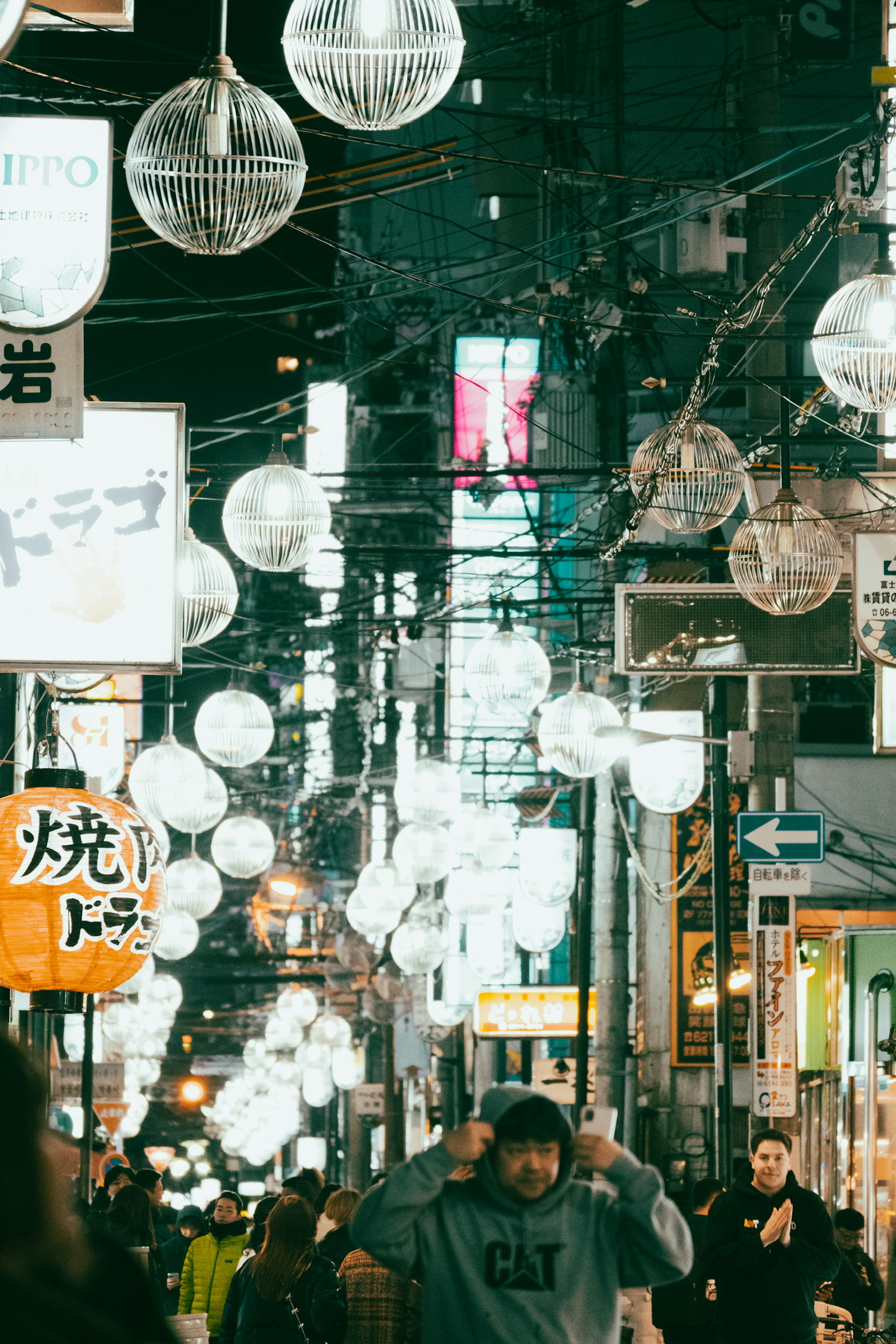 A bustling street scene at night with glowing lanterns and people walking