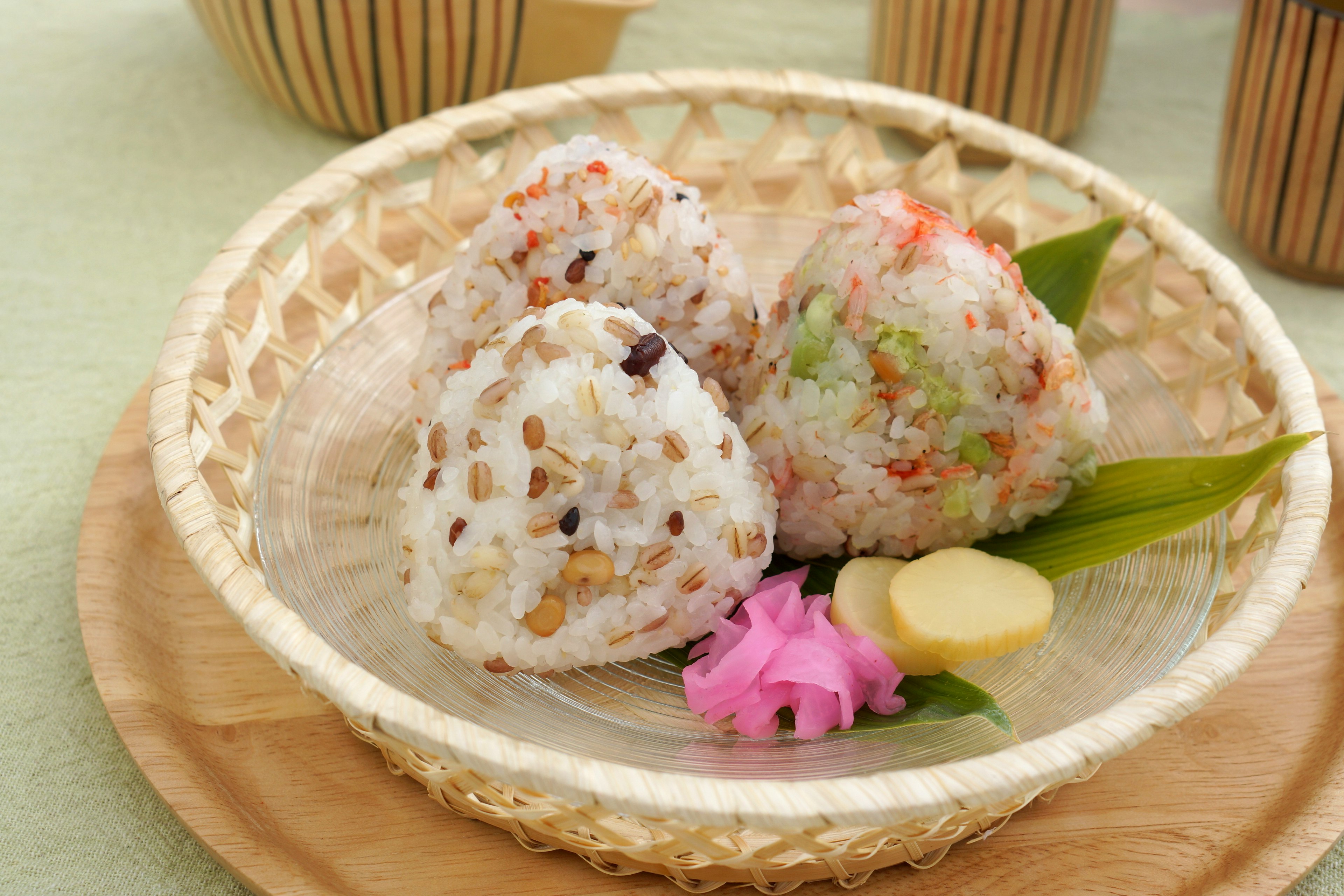 Belles boules de riz présentées dans un panier en bambou avec des garnitures colorées