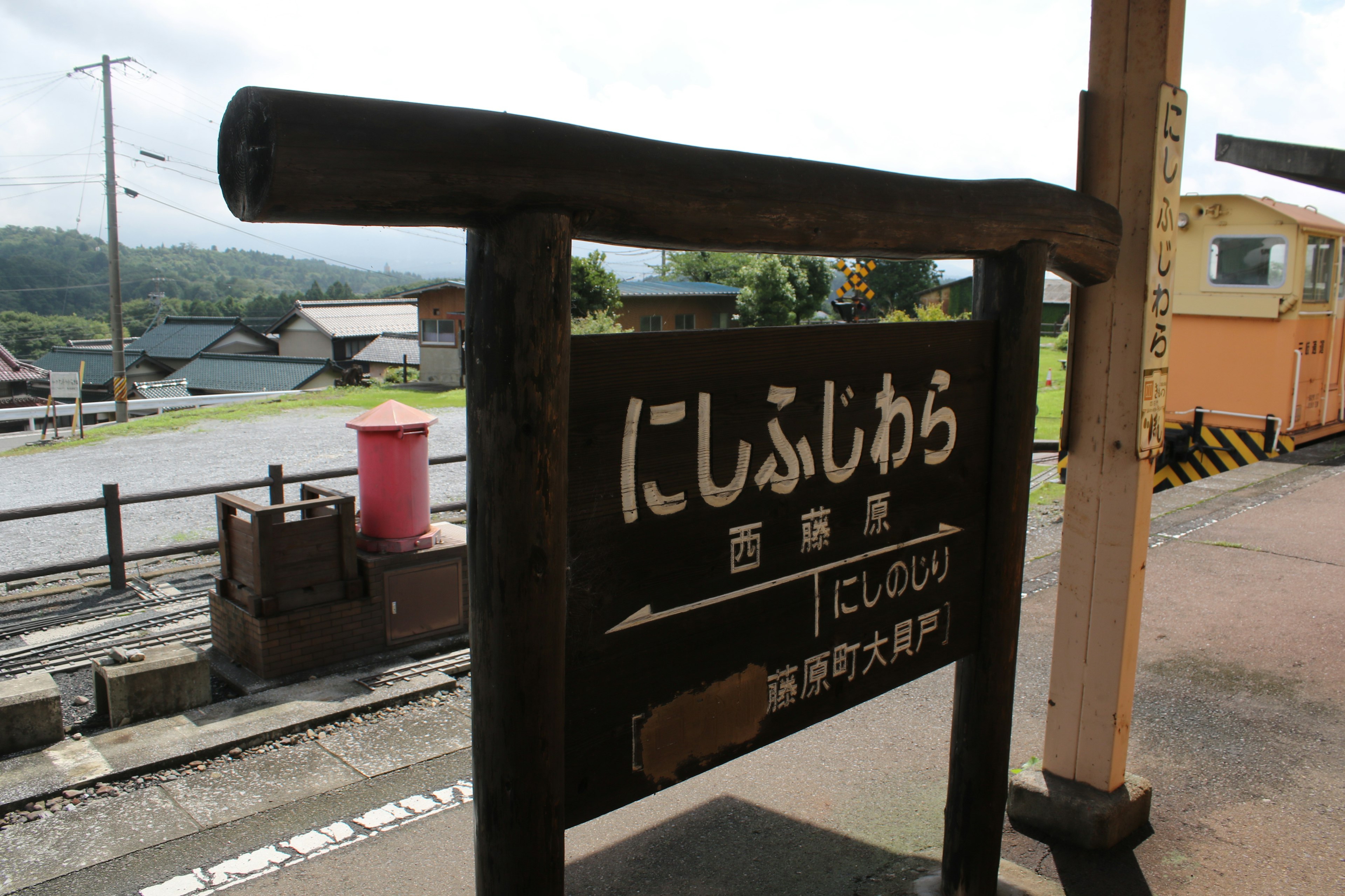 にしふじしら駅の看板と周囲の風景