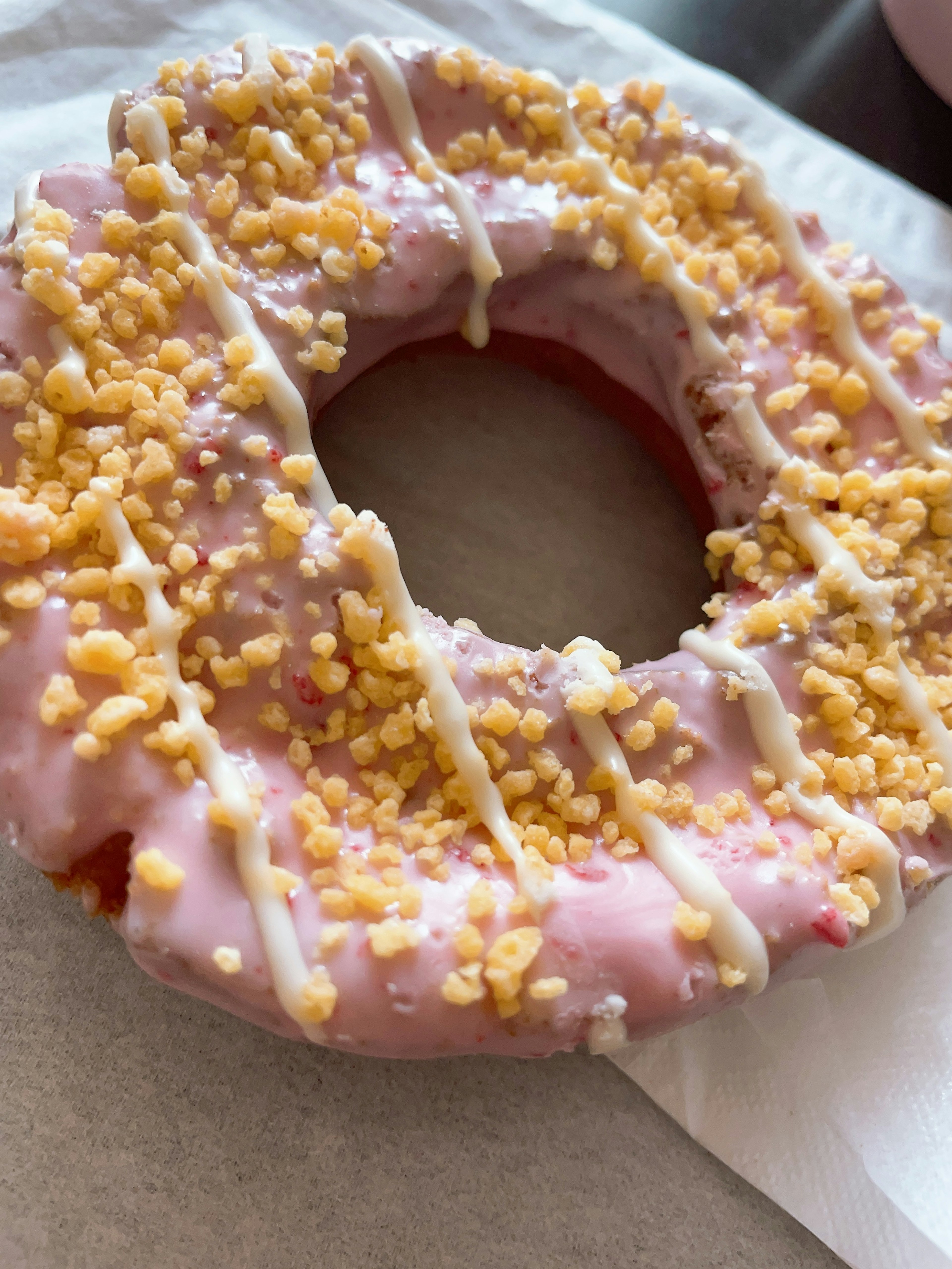 Pink iced donut with crunchy topping