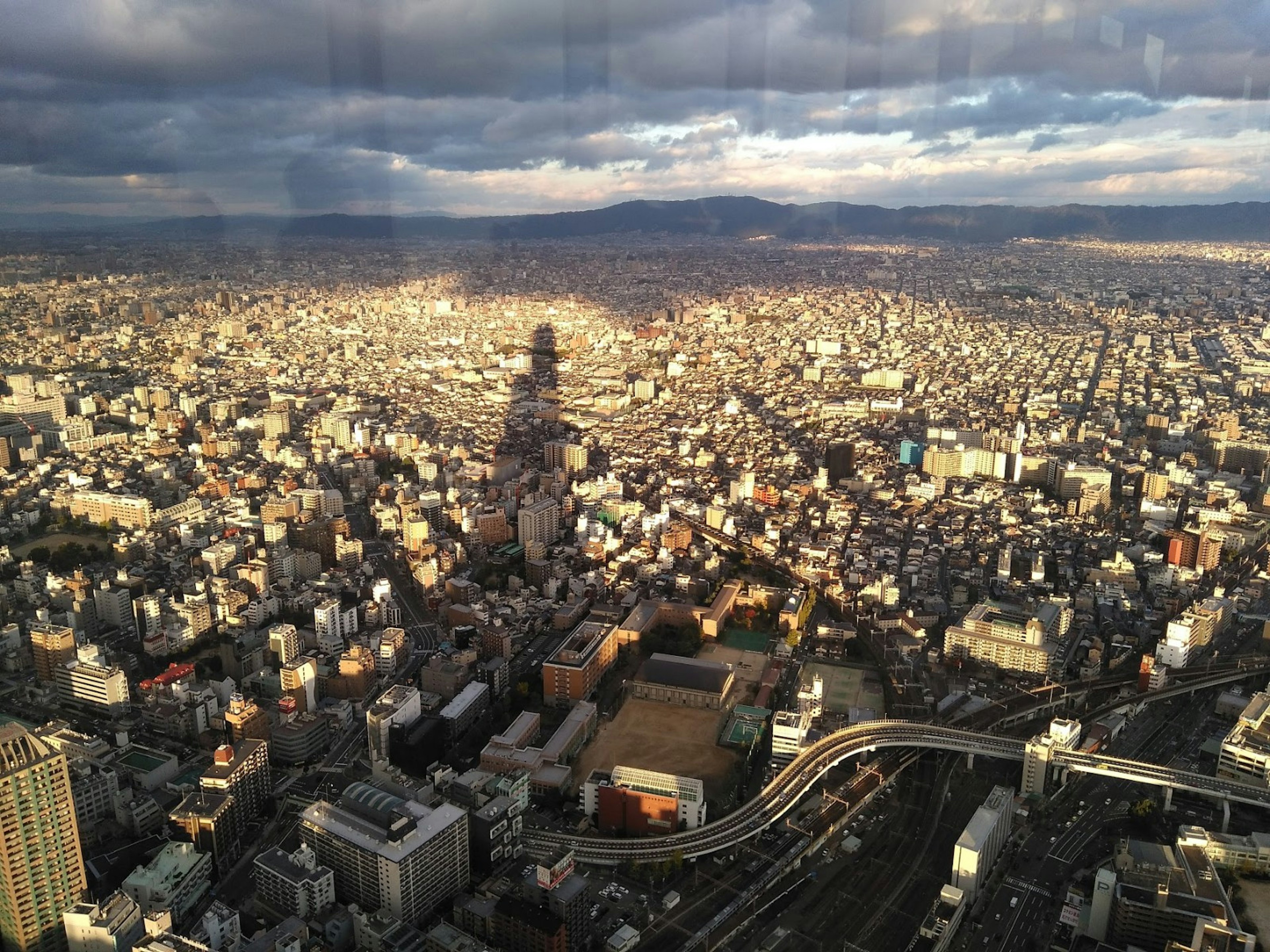 高層ビルの眺めを持つ都市の広がりと雲のある空