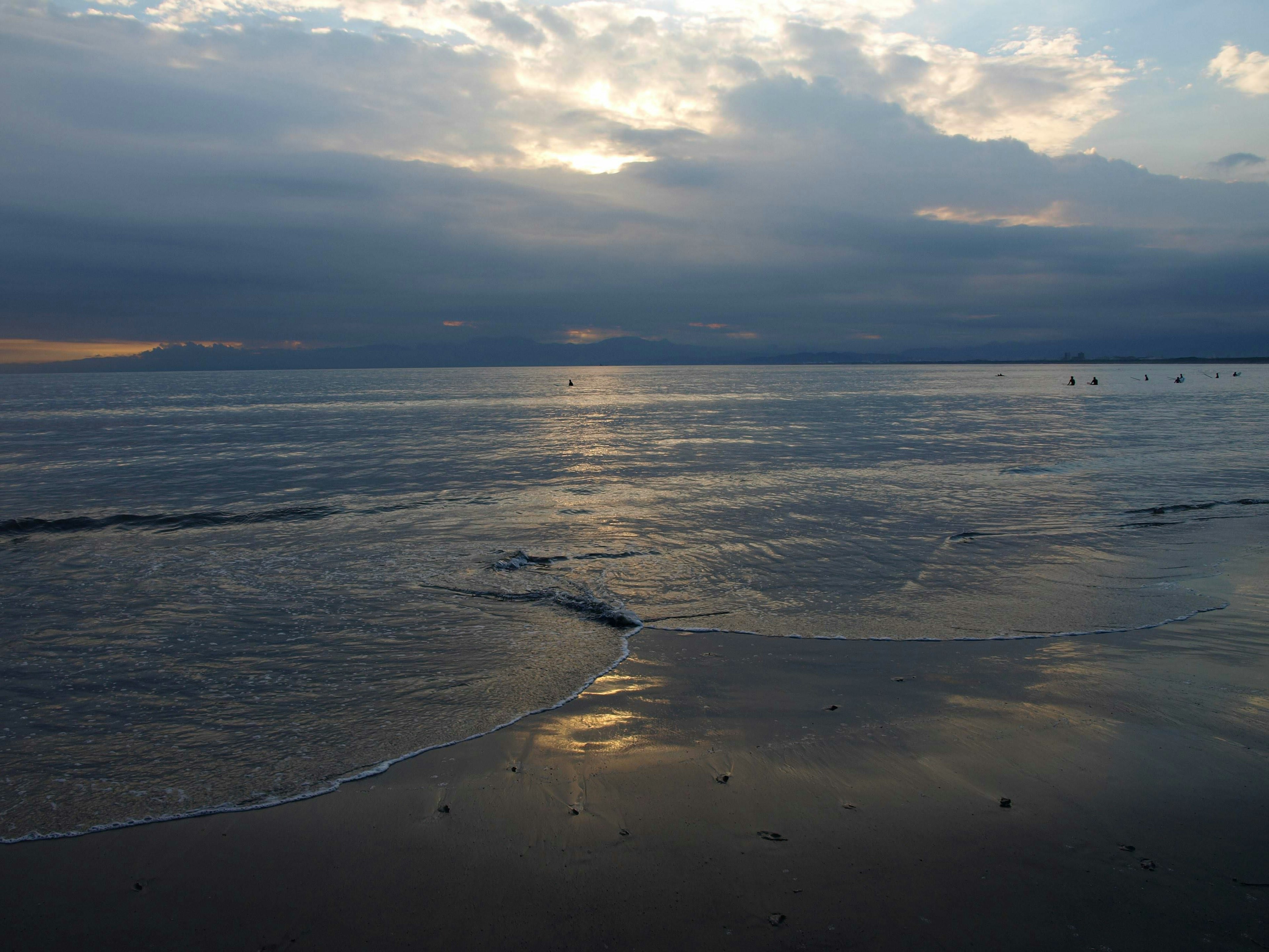 Paesaggio marino con cielo nuvoloso che riflette la luce del tramonto