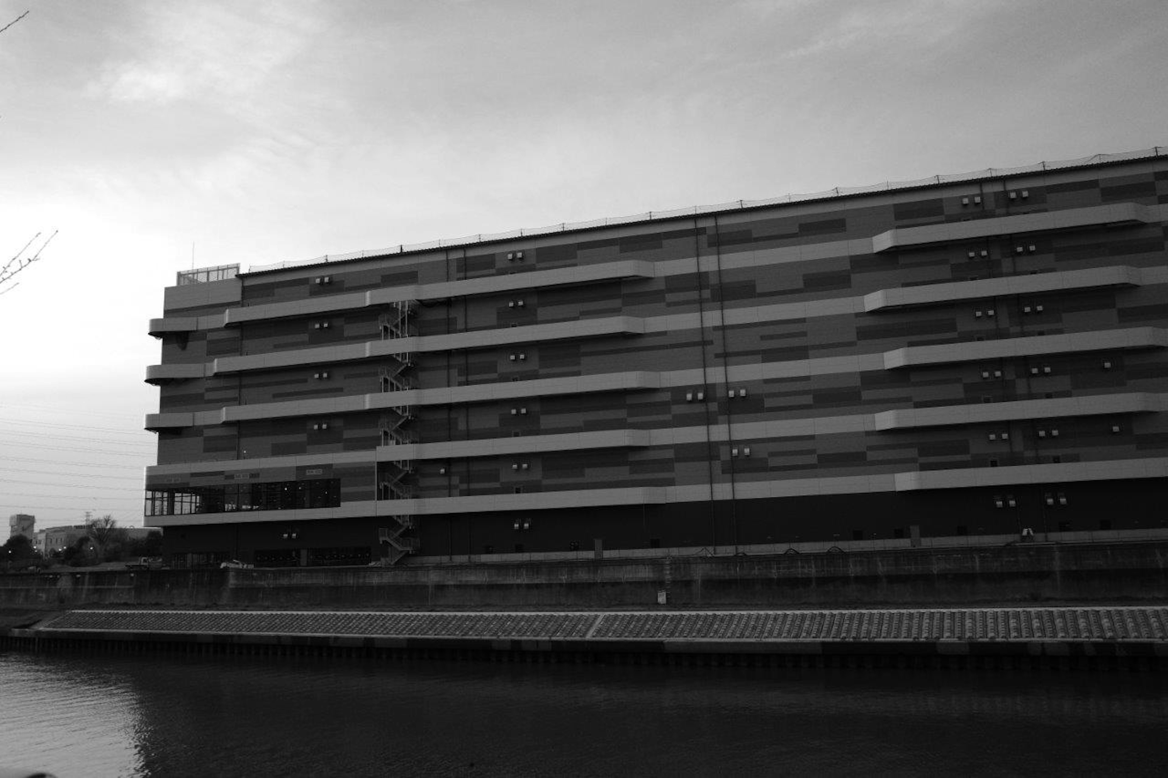 Image en noir et blanc d'un bâtiment moderne au bord de l'eau