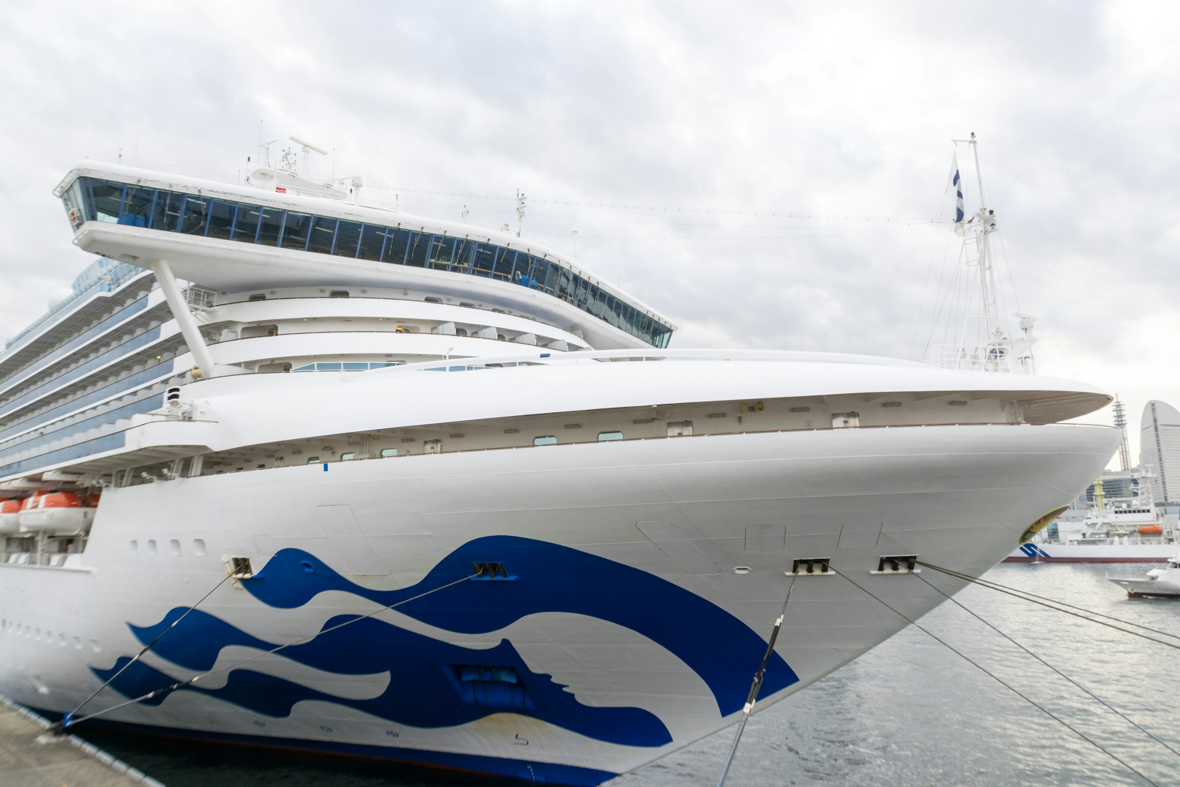 Barco de crucero de lujo con diseño de olas azules en el muelle