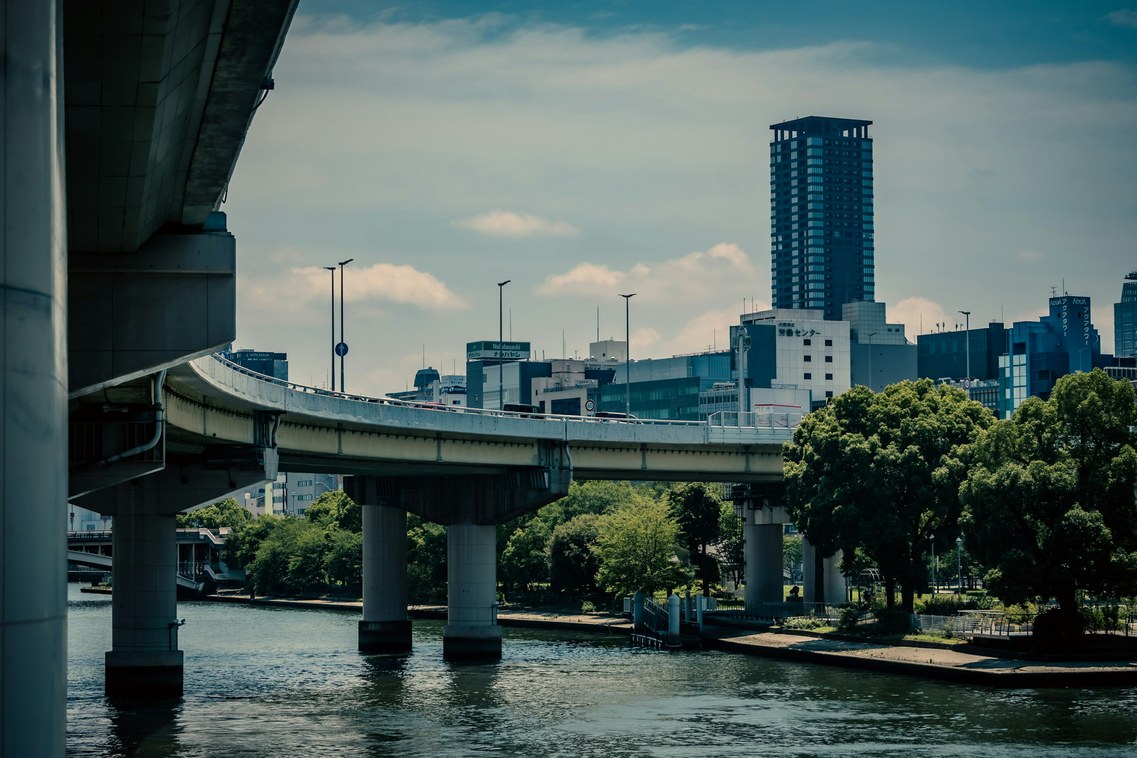 橋と都市の風景が映る川の写真