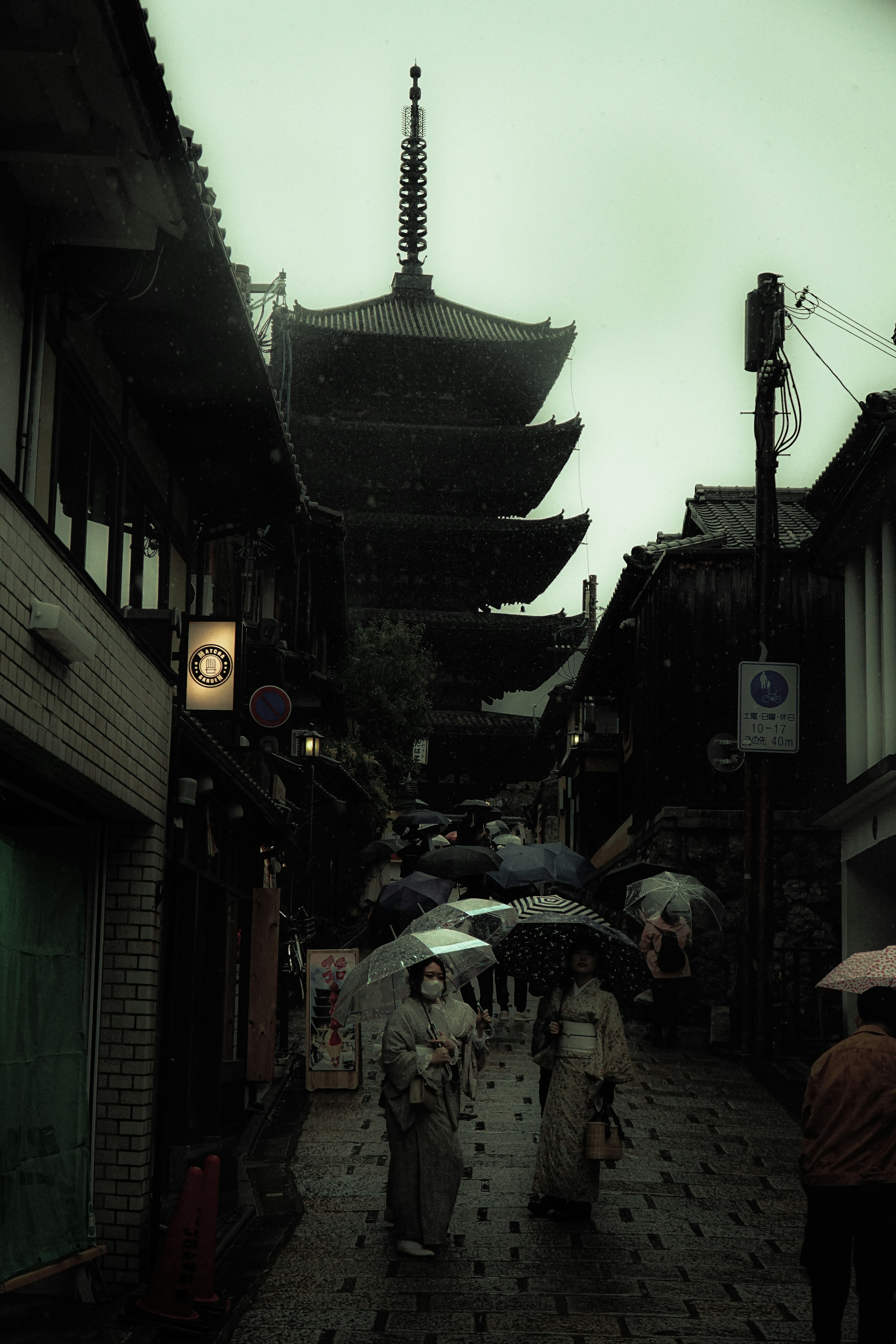 Escena de calle japonesa tradicional con pagoda bajo la lluvia