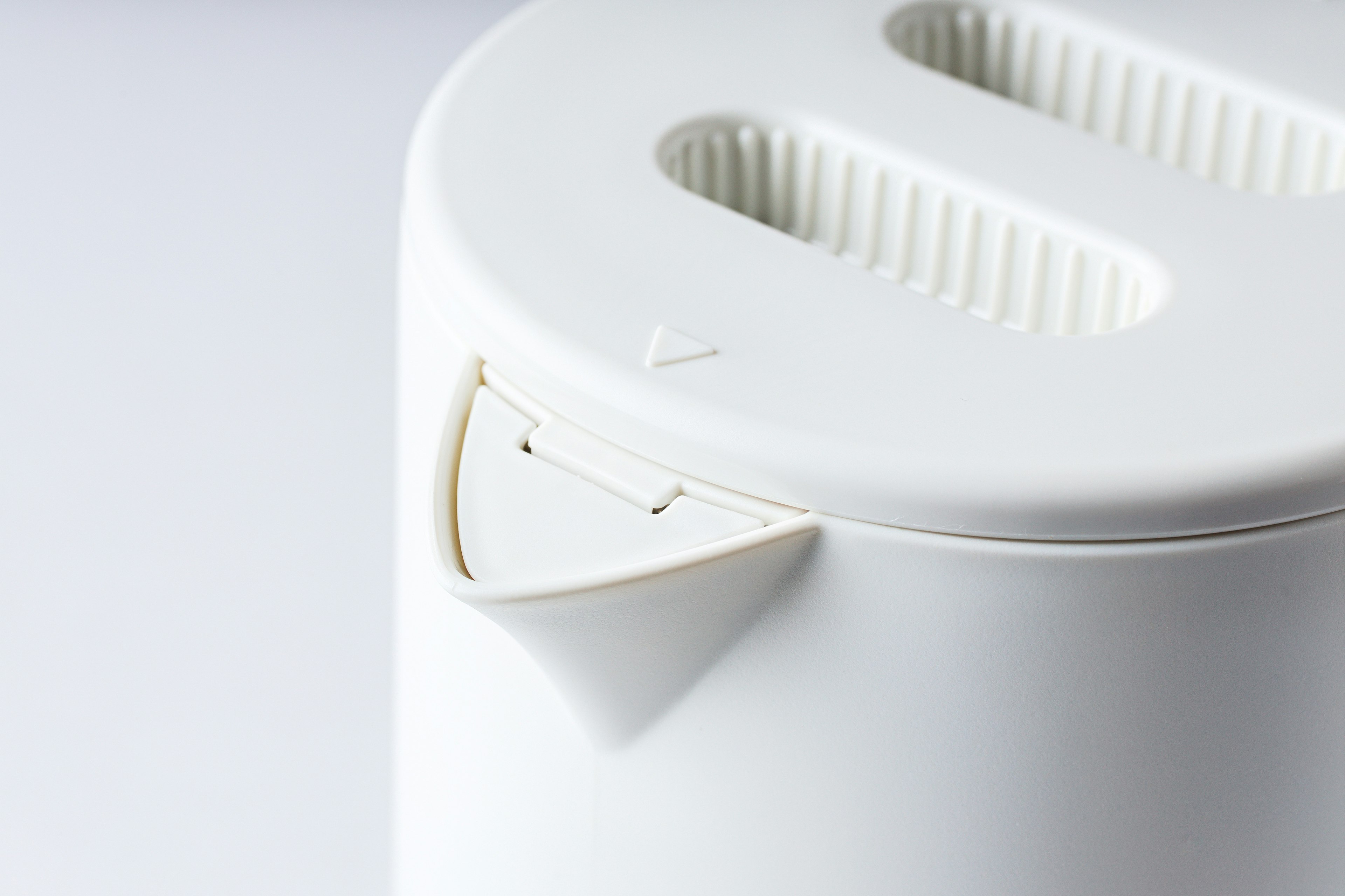 Close-up of a white toaster top featuring two slots for slices and a simple modern design